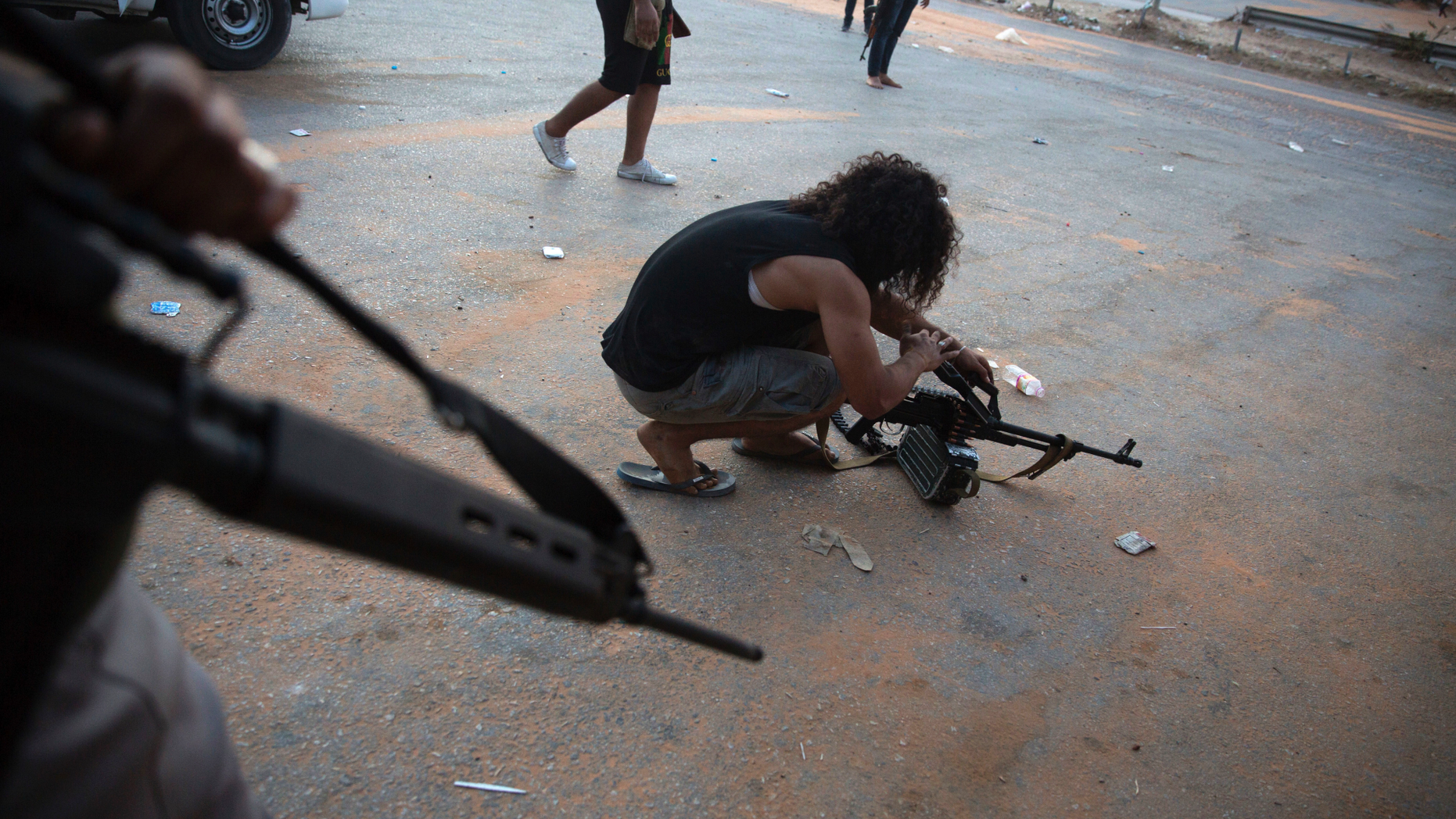 FILE - In this Sept. 21, 2018 file photo, a fighter under the UN-backed government prepares his gun during clashes in southern Tripoli, Libya. Various militias, many of which are little more than criminal gangs, are mobilizing to fight over the capital, Tripoli after forces led by self-styled Libyan National Army, led by Field Marshal Khalifa Hifter, launched a surprise offensive to retake Tripoli on April 5, 2019, from the transitional government supported by U.N. and Western nations led by Fayez Sarraj. Hifter's opponents view him as an aspiring dictator. (AP Photo/Mohamed Ben Khalifa, File)