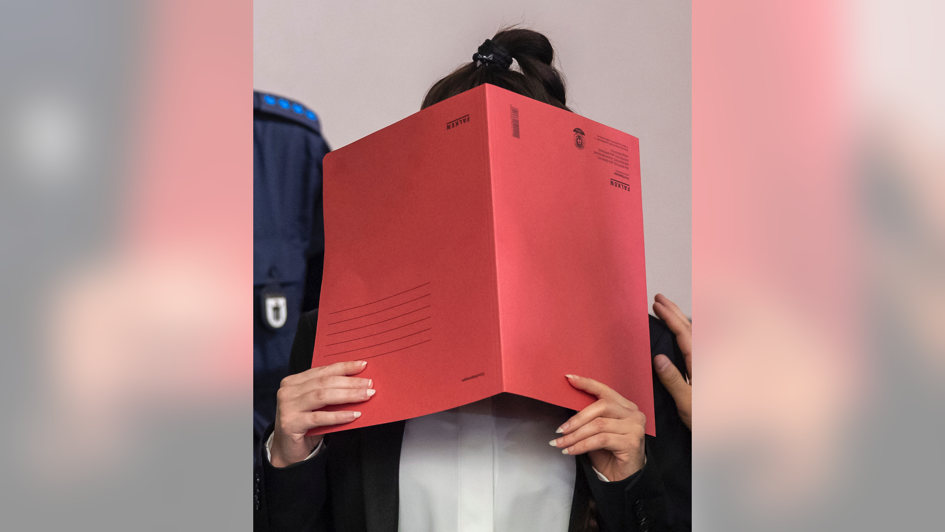 27-year-old German Jennifer W. covers her face as she arrives at a court in Munich, southern Germany, Tuesday, April 9, 2019. The woman is accused of letting a 5-year-old girl she and her husband held as a slave in Islamic State-held territory in Iraq die of thirst. (Peter Kneffel/dpa via AP)