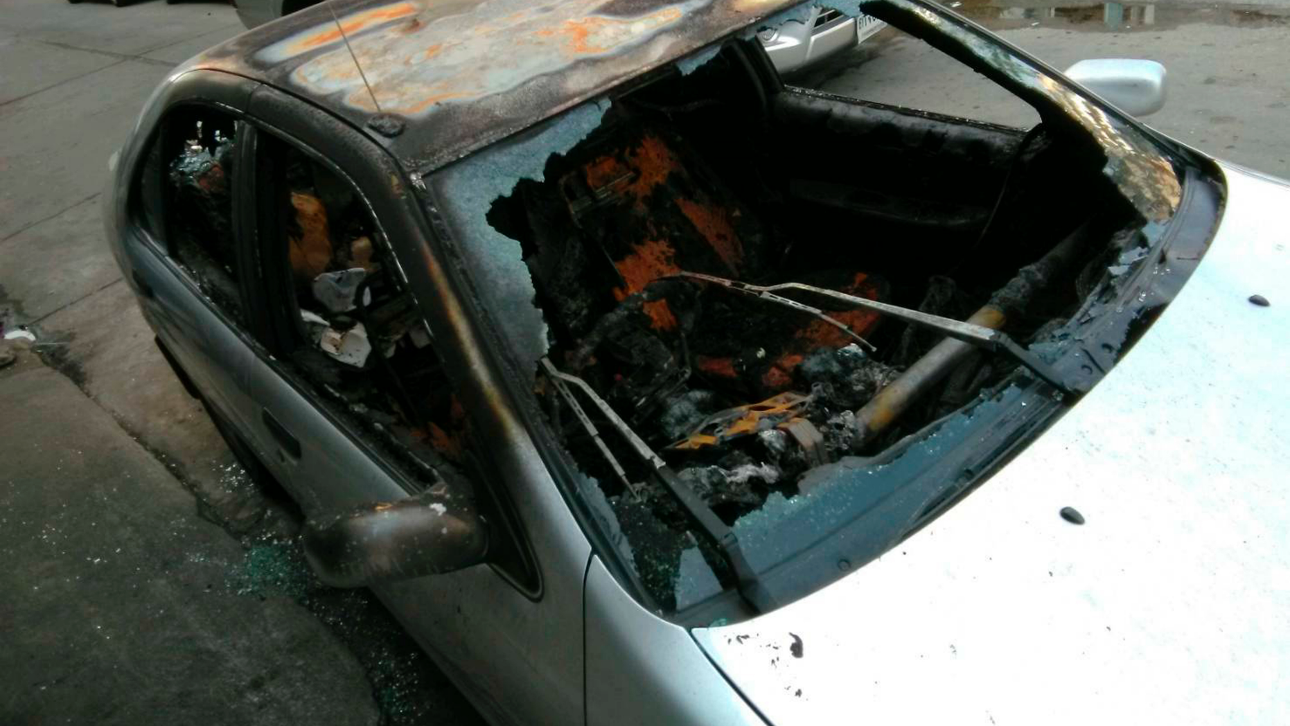 In this photo released by anti-military rule activist Ekachai Hongkangwan, the personal vehicle owned by Ekachai sits destroyed by fire on the side of a road early Monday, April 1, 2019, in Bangkok, Thailand, hours after he attended a rally calling the recent general elections mismanaged. Ekachai has been the repeated target of physical and legal attacks, including a previous one on his car that did less damage. On March 5, he was attacked by two unidentified men on a motorcycle who tried to beat him with a wooden stick and a metal pipe. (Ekachai Hongkangwan via AP)