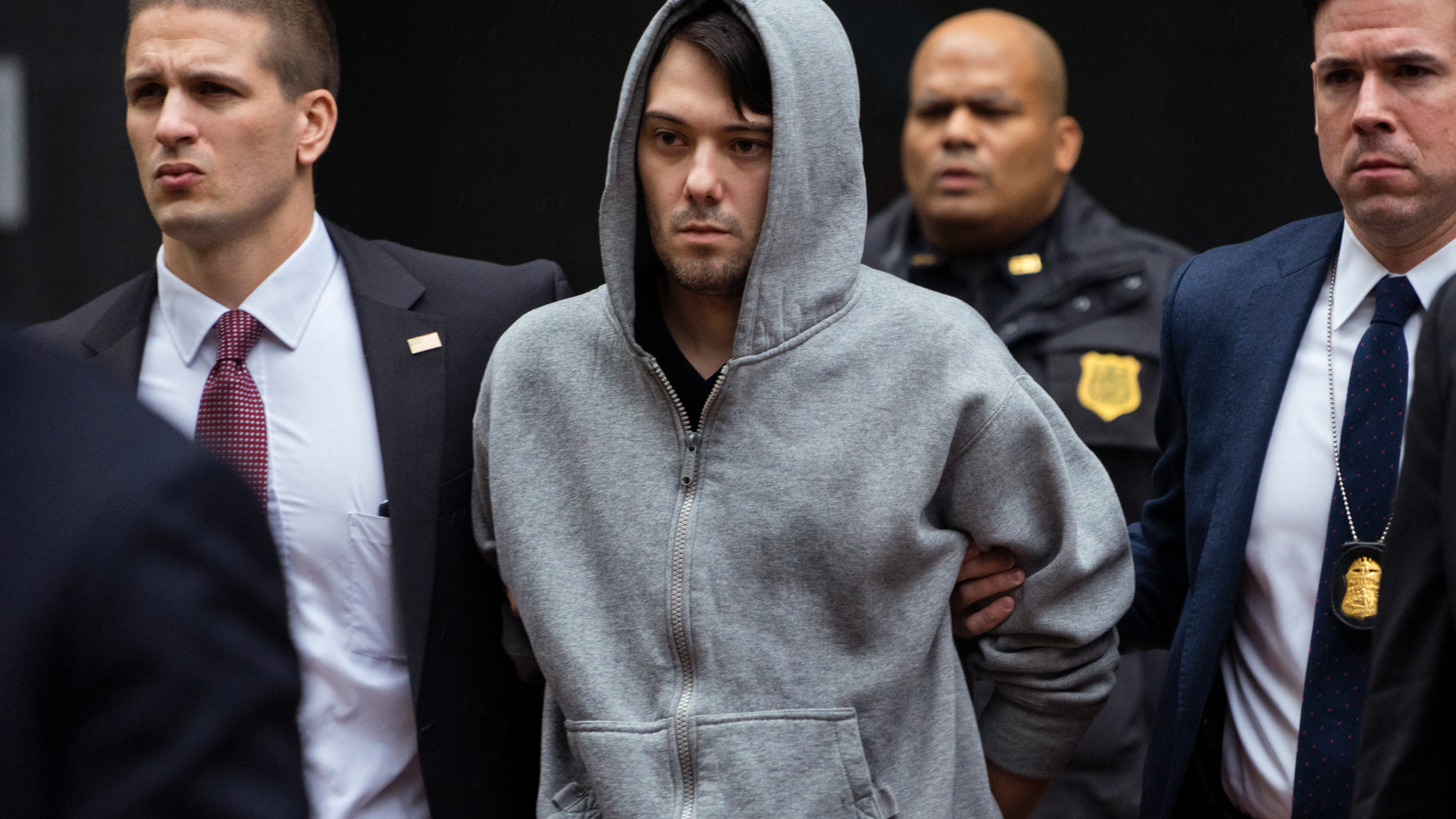 FILE - In this Dec. 17, 2015, file photo, Martin Shkreli, the former hedge fund manager under fire for buying a pharmaceutical company and ratcheting up the price of a life-saving drug, is escorted by law enforcement agents in New York, after being taken into custody following a securities probe. Pharmaceutical honcho Shkreli has been banished to solitary confinement amid allegations he was running his drug company from federal prison using a contraband smartphone, a person familiar with the matter told The Associated Press. (AP Photo/Craig Ruttle, File)