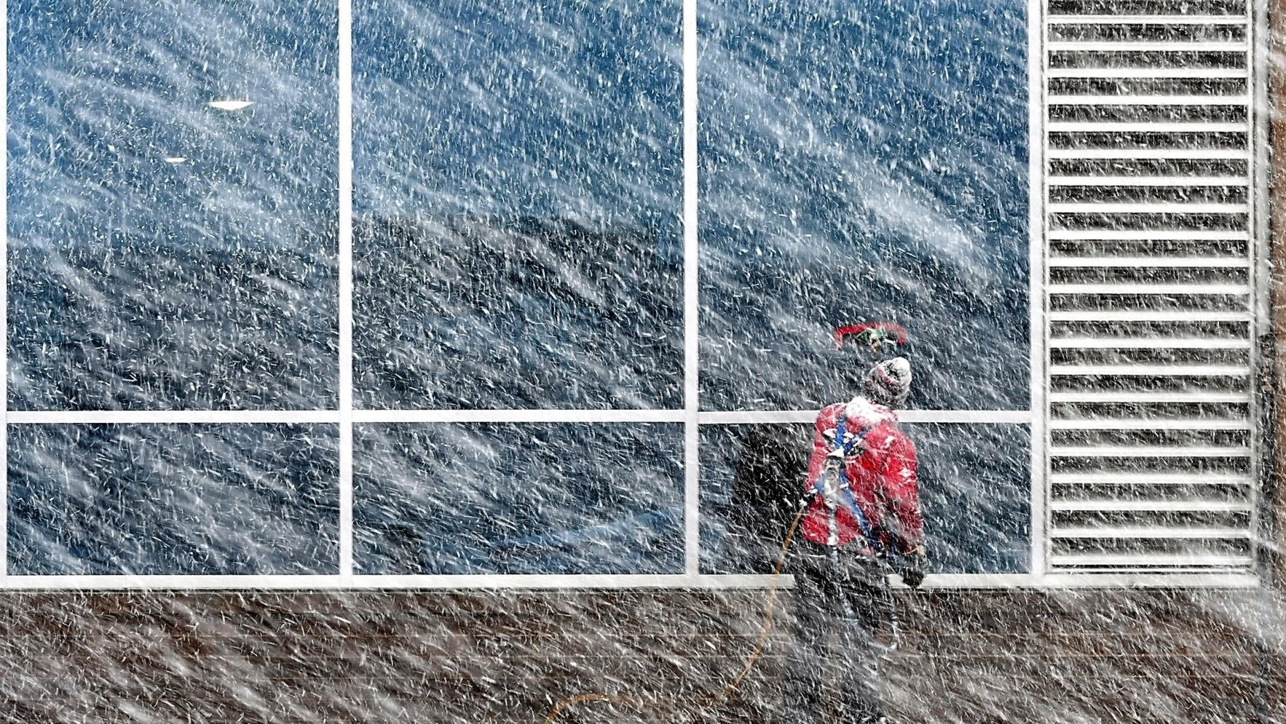 Xavier Castillo of Endres Window Cleaning finishes up a set of windows on the Profinium building in downtown Mankato, Minn., as snow falls Wednesday, Apr. 10, 2019. (Pat Christman/The Free Press via AP)