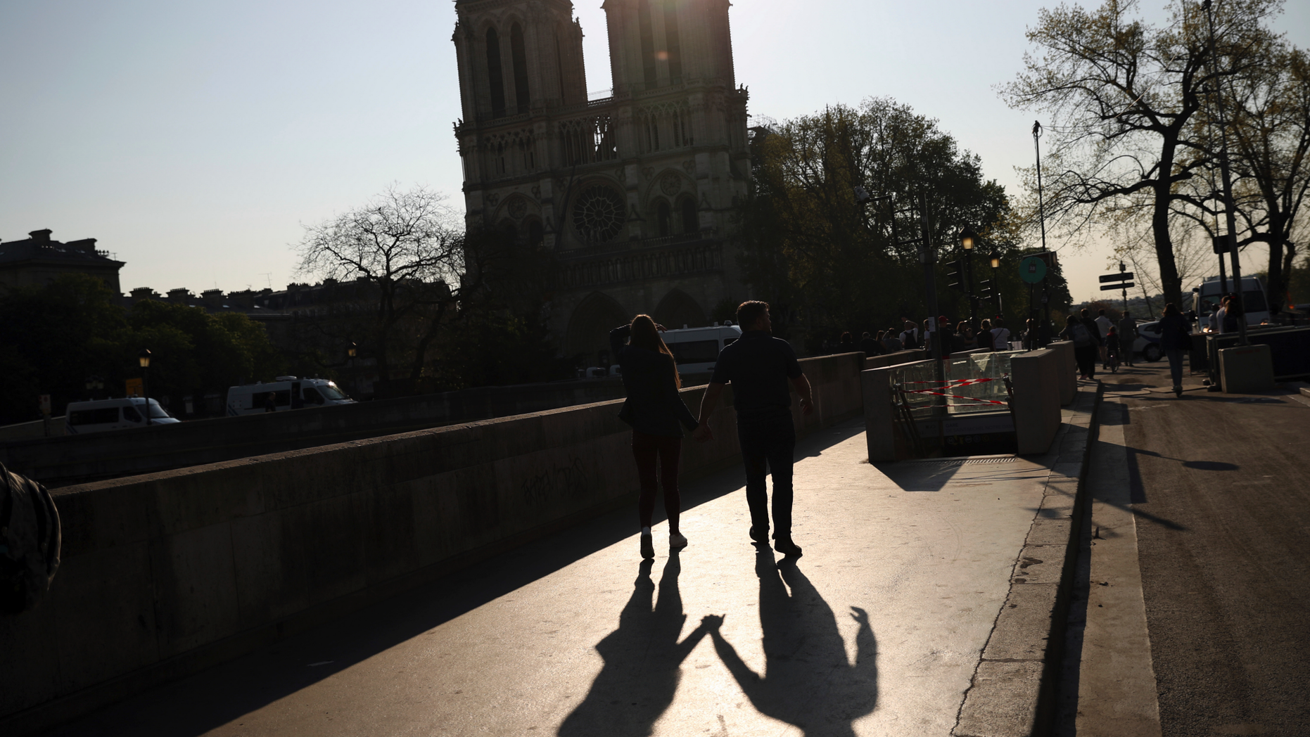Two people walk by a the Notre Dame Cathedral in Paris, Saturday, April 20, 2019. Yellow vest protests are scheduled to take place in Paris and other regions of France over the weekend, with a heightened security presence anticipated. (AP Photo/Francisco Seco)