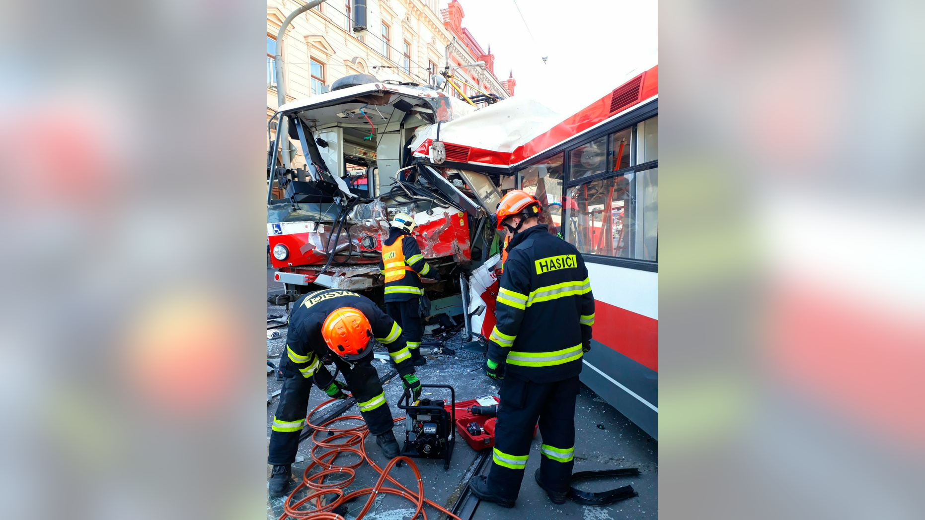 In this handout photo taken on Monday April 1, 2019, firemen stand by a tram that has collided with trolleybus in Brno, Czech Republic. Officials say a tram collided with a trolleybus head on in the Czech second largest city, injuring dozens of passengers. Michaela Bothova, a spokeswoman for the rescue service says at least five people have suffered serious injuries while another 20 passengers were injured lightly. (HZS JMK via AP)