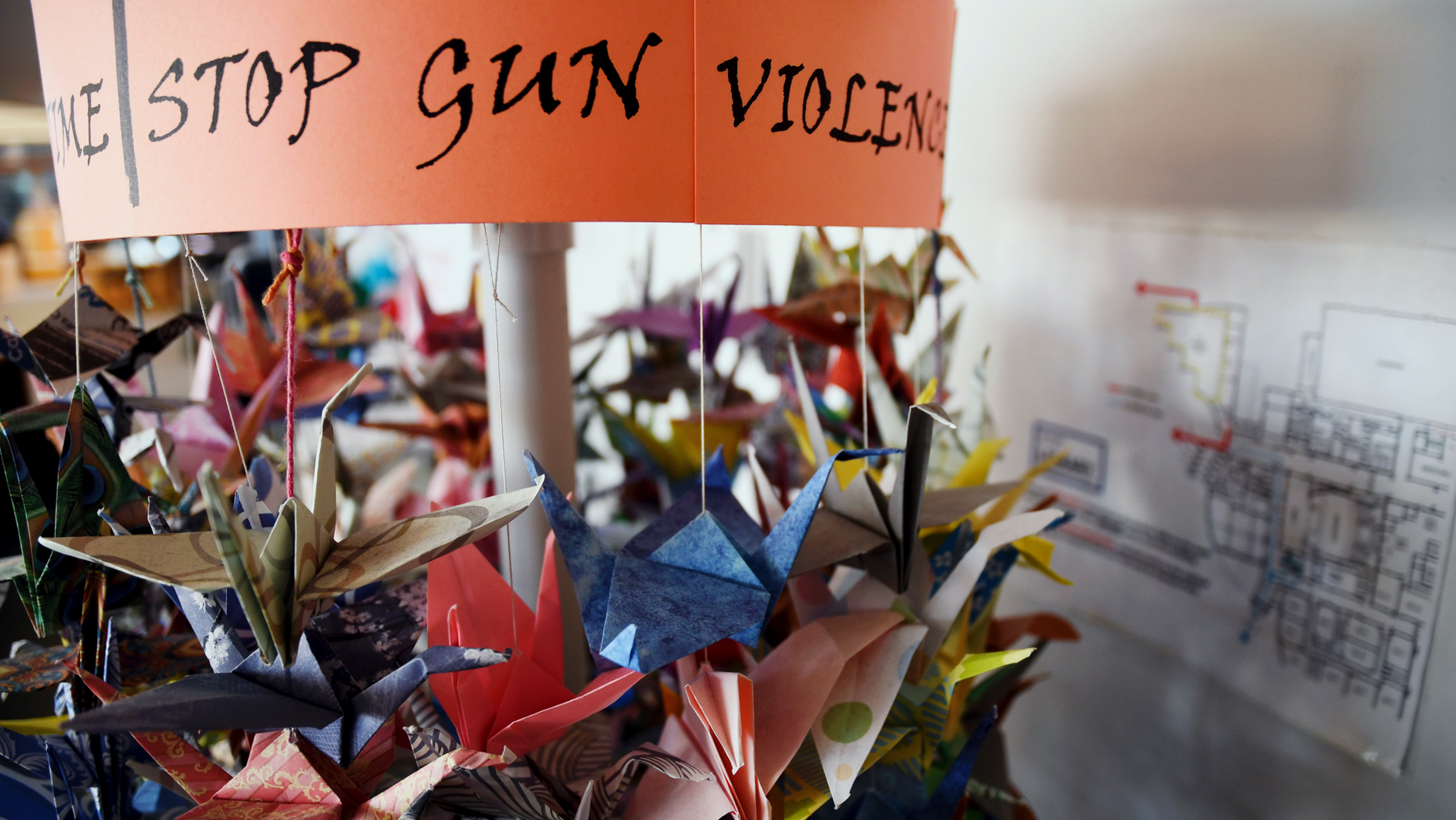 FILE - In this March 23, 2019, file photo, origami cranes, a symbol of peace, hang in the Columbine High School library in Littleton, Colo., near where several survivors and family members of the victims gathered to speak about the upcoming 20th anniversary of the April 20, 1999, shooting. In the two decades since the Columbine High School massacre, therapists still struggle with how to help people cope. (AP Photo/Thomas Peipert, File)