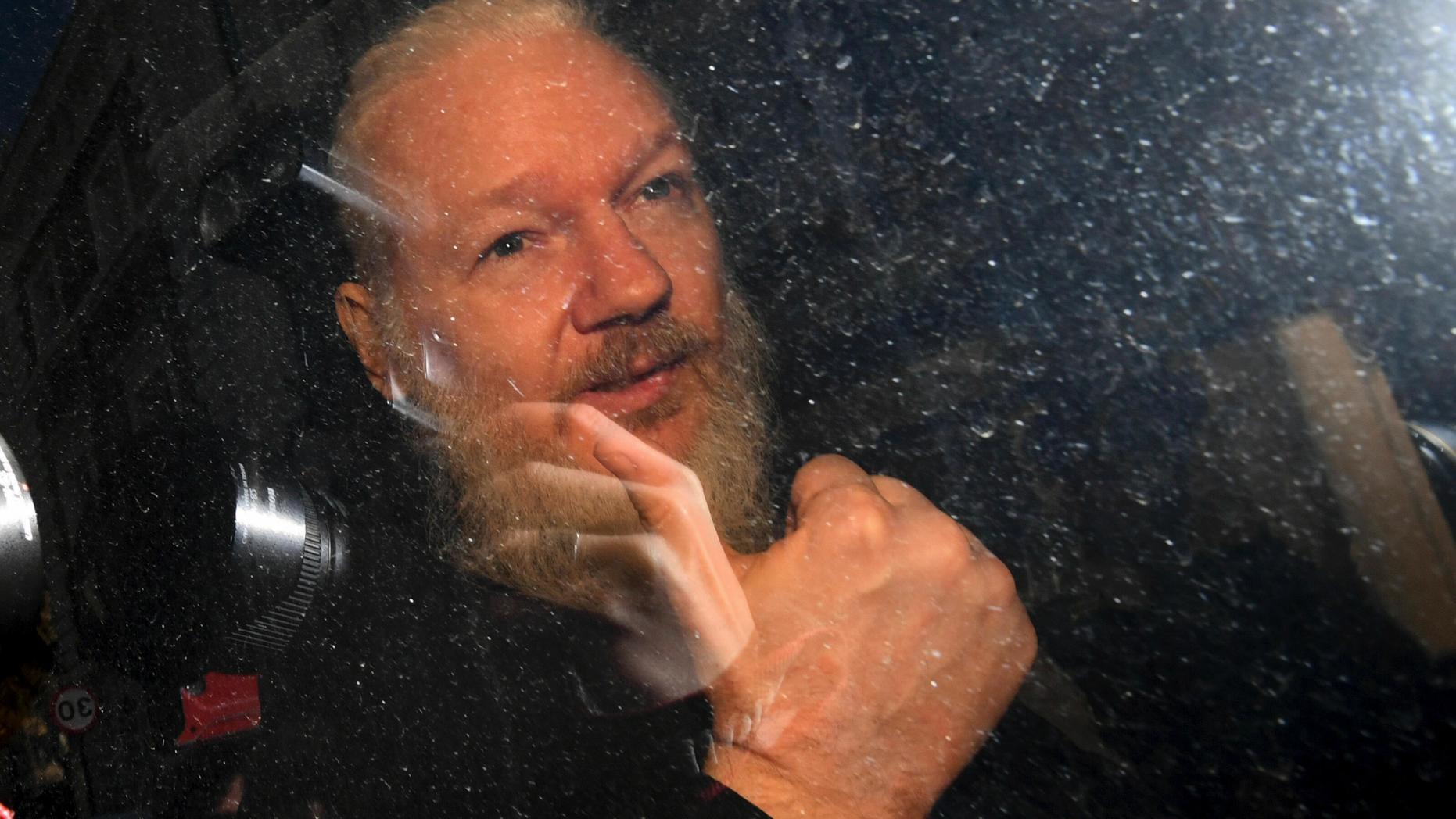 Julian Assange gestures as he arrives at Westminster Magistrates' Court in London, after the WikiLeaks founder was arrested by officers from the Metropolitan Police and taken into custody Thursday April 11, 2019. Police in London arrested WikiLeaks founder Assange at the Ecuadorean embassy Thursday, April 11, 2019 for failing to surrender to the court in 2012, shortly after the South American nation revoked his asylum .(Victoria Jones/PA via AP)