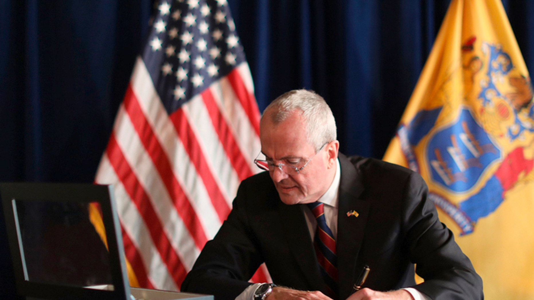 In this photo courtesy of the Governor's Office in New Jersey, NJ Governor Phil Murphy signs the Physician-assisted Death for Incurable Patients syndrome on Friday, April 12, 2019 at the New Jersey Statehouse in Trenton. in New Jersey. enact legislation allowing terminally ill patients to seek end-of-life drugs. (Governor's Office in New Jersey via AP)