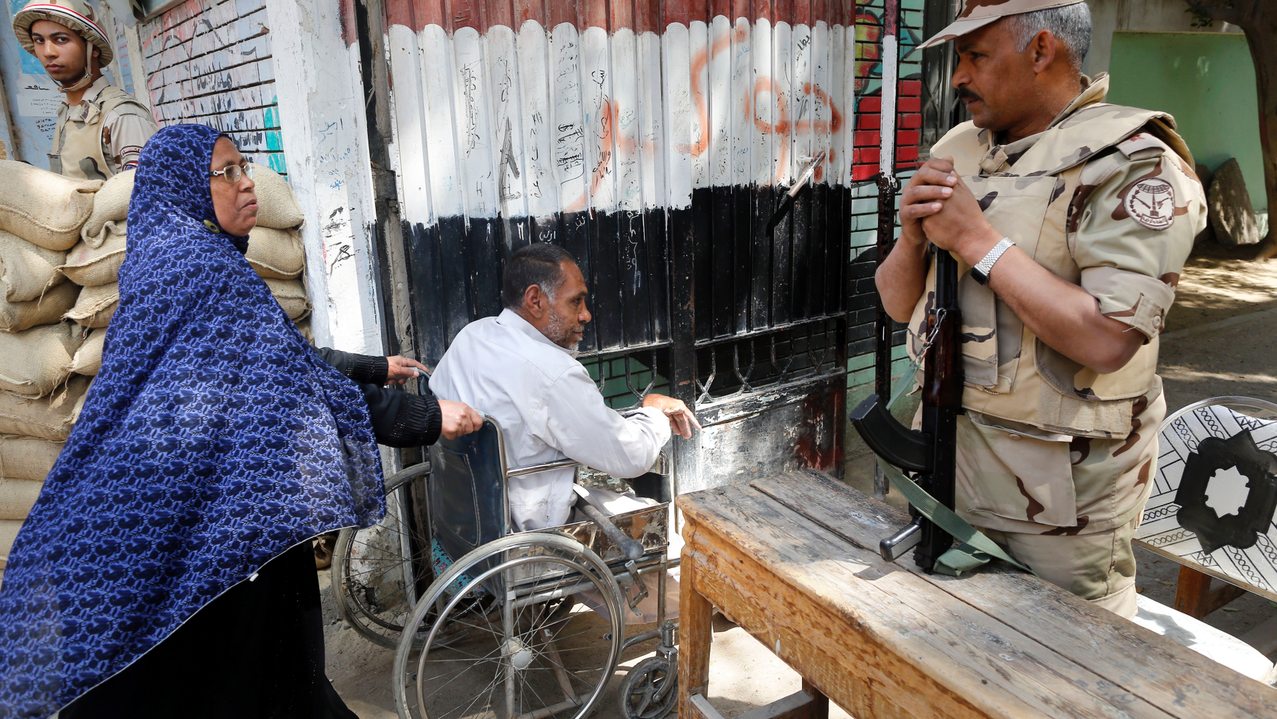 Army officers secure a polling station as people enter to vote on constitutional amendments on the second day of a nationwide referendum in Cairo, Egypt, Sunday April 21, 2019. Egyptians are voting on constitutional amendments that would allow el-Sissi to stay in power until 2030. (AP Photo/Amr Nabil)