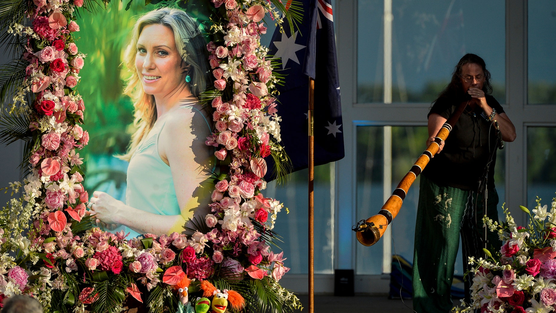 FILE - In this Aug. 11, 2017, file photo, Johanna Morrow plays the didgeridoo during a memorial service for Justine Ruszczyk Damond at Lake Harriet in Minneapolis. Jury selection is scheduled to begin, Monday, April 1, 2019, in the trial of a former Minneapolis police officer who fatally shot the unarmed Australian woman after she called 911 to report a possible sexual assault behind her home. Mohamed Noor is charged with murder in the July 2017 death of Damond - a case that drew international attention and led to changes at the city's police department. He has pleaded not guilty. (Aaron Lavinsky/Star Tribune via AP, File)