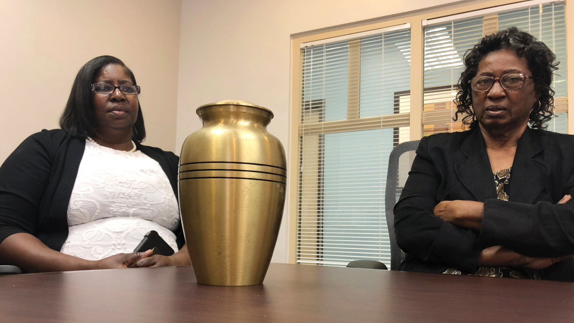 Corene Nero, right, and her daughter Gloria Rolle speak at their attorneys office next to an urn with cremated remains, in Boca Raton, Fla., Tuesday, April 16, 2019. Robert Nero Sr., passed away in 2013 and was cremated by Taylor Smith funeral home. In March, West Palm Beach police Department found a box with Robert Nero's name on it filled with ashes. Now the family is demanding answers from the funeral home and want to return the remains they have to the right family. (AP Photo/Josh Repogle)