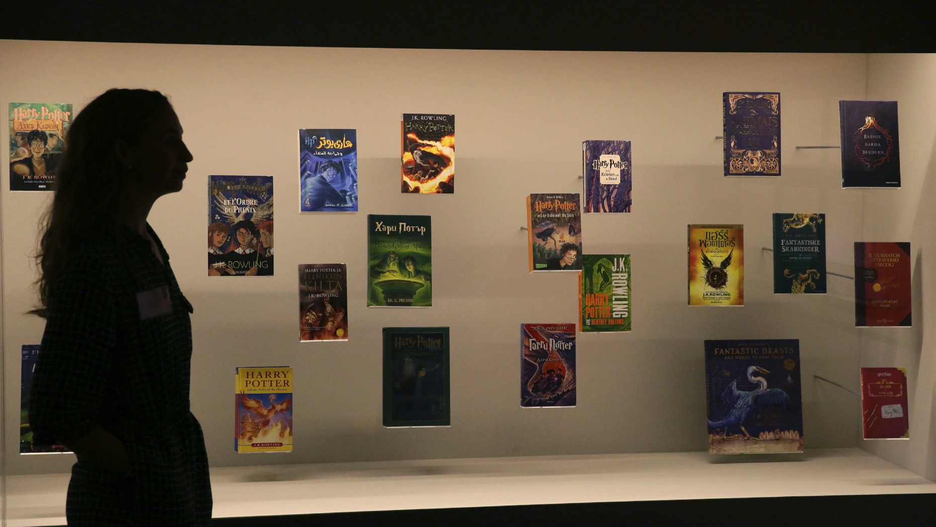 FILE - In this Wednesday Oct. 18, 2017 file photo, a member of British Library staff poses for a picture with Harry Potter books published in several languages at the "Harry Potter - A History of Magic" exhibition at the British Library, in London. Priests at a Catholic parish in northern Poland have burned books, including the “Harry Potter” series, and other items that their owners said had evil forces. Images from the burning at Gdansk’s Mother of Church parish on Sunday March 31, 2019, were posted on Facebook by a Catholic foundation that uses unconventional ways of religious work. (AP Photo/Tim Ireland, File)