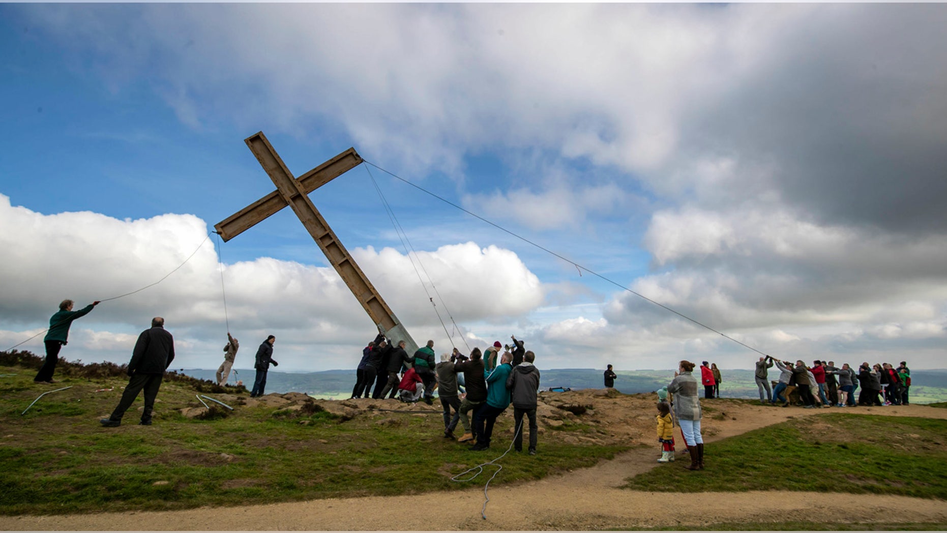 Over 50 people work to install a 36-feet high cross ahead of Easter on Surprise View at the top of Otley Chevin hill, England, Saturday, April 6, 2019. The Chevin cross has become a well-known Easter symbol, normally erected two weeks before Easter, made from wood salvaged after the 1996 Provisional Irish Republican Army (IRA) bomb which devastated part of central Manchester. (Danny Lawson/PA via AP)