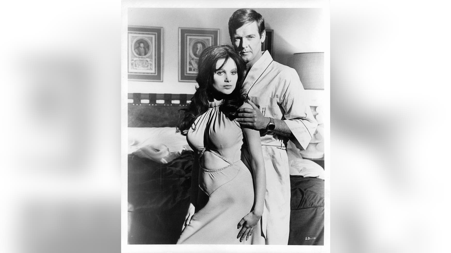 Madeline Smith leaning against Roger Moore in a suggestive manner as he touches her arm in a scene from the film "Live And Let Die," 1973. — Photo by United Artist/Getty Images