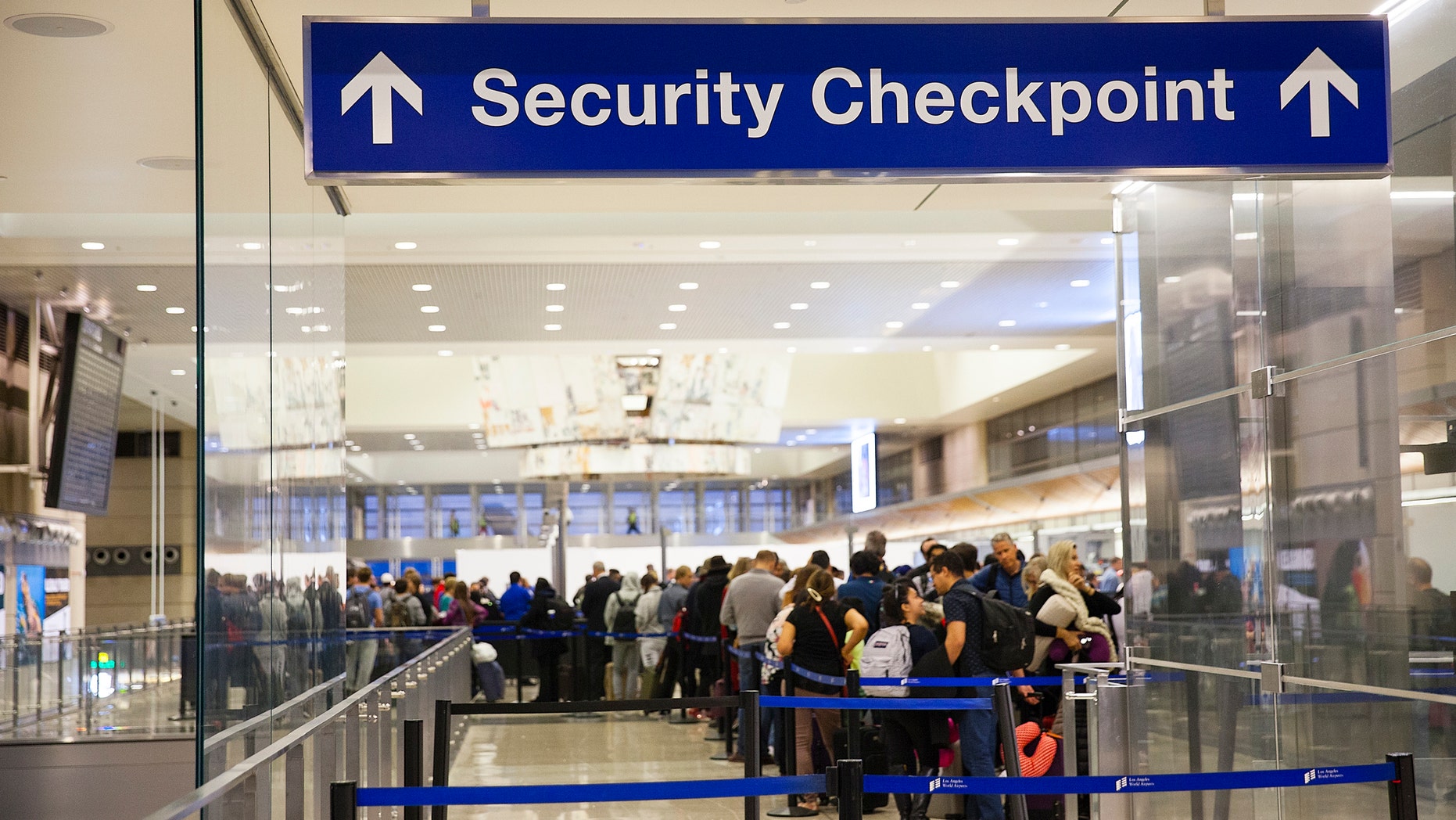 Los Angeles, California, USA-December 2017: Airport Sign at the entrance of the security checkpoint in LAX airport with People waiting in line.