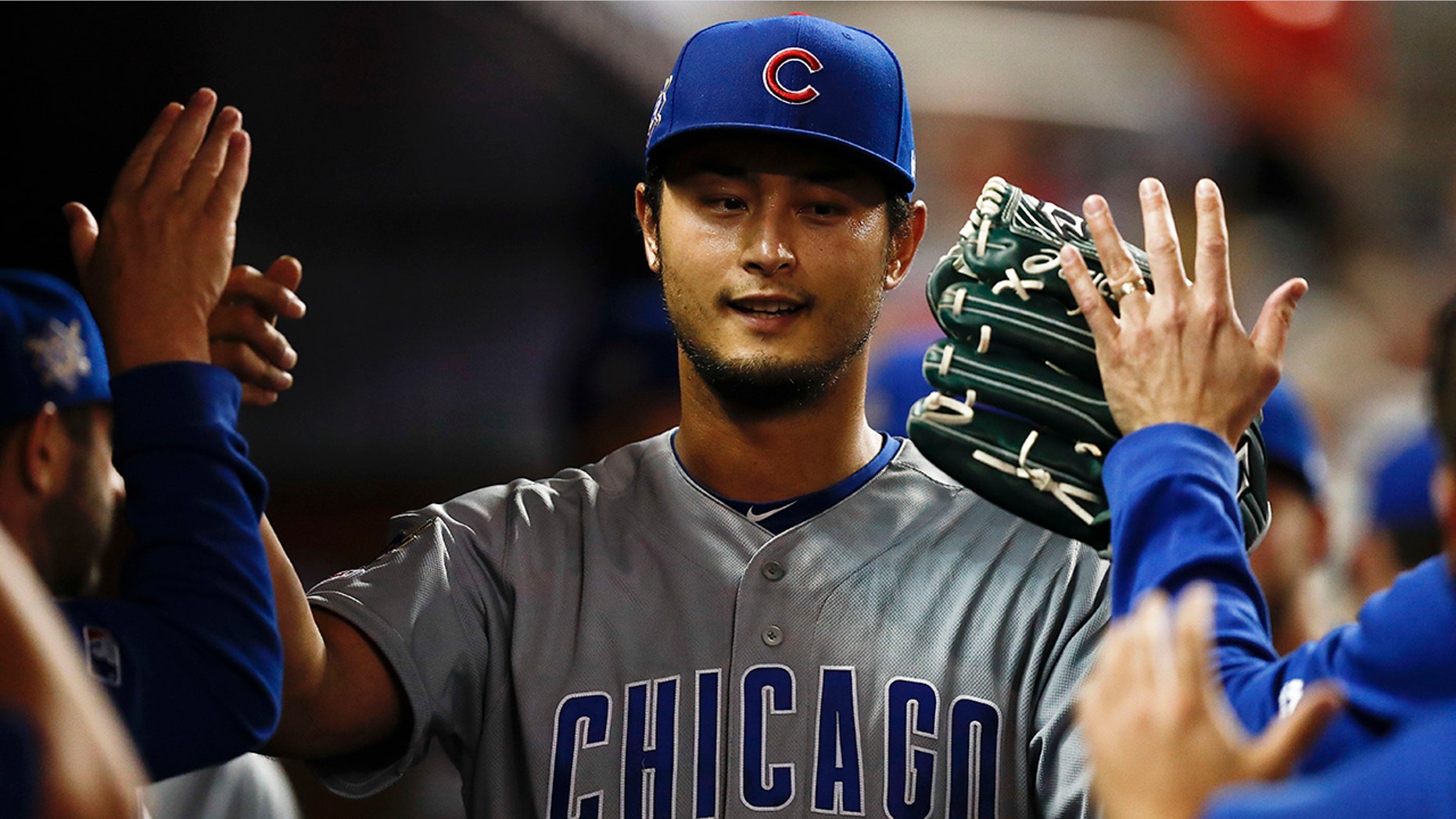 Chicago Cubs starting pitcher Yu Darvish high-fives teammates after being taken out of a baseball game during the seventh inning against the Miami Marlins, Monday, April 15, 2019, in Miami. (AP Photo/Brynn Anderson)