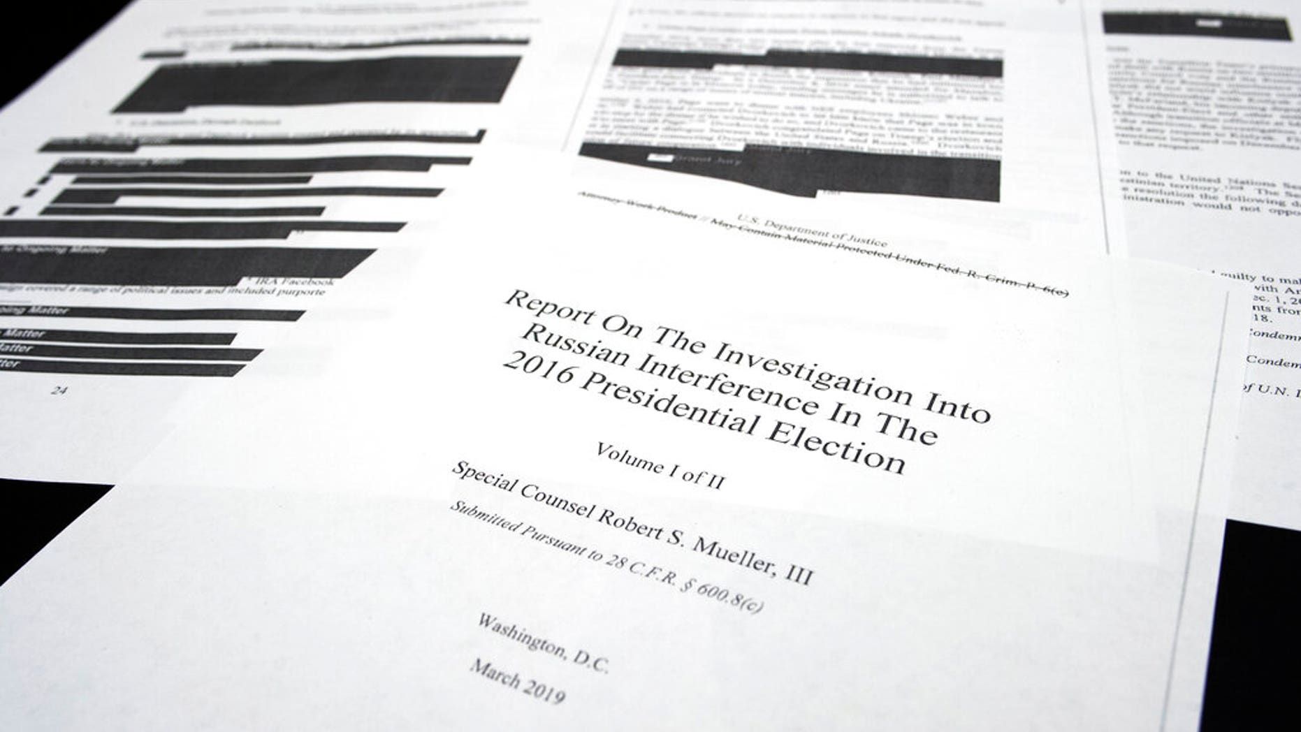 Four pages of the Mueller Report lay on a witness table in the House Intelligence Committee hearing room on Capitol Hill, in Washington, Thursday, April 18, 2019. (AP Photo/Cliff Owen)