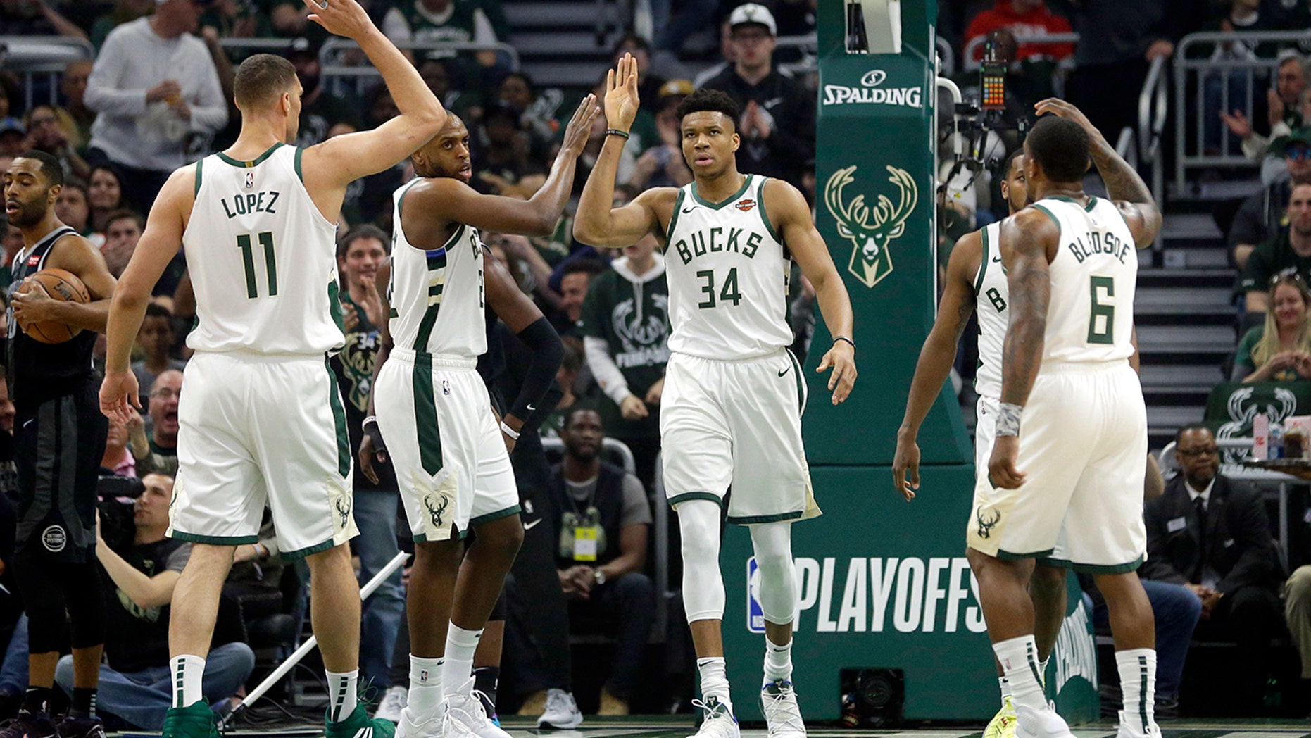 Milwaukee Bucks' Giannis Antetokounmpo gives high-fives to his teammates during the first half of Game 2 of an NBA basketball first-round playoff series against the Detroit Pistons on Wednesday, April 17, 2019, in Milwaukee. (AP Photo/Aaron Gash)