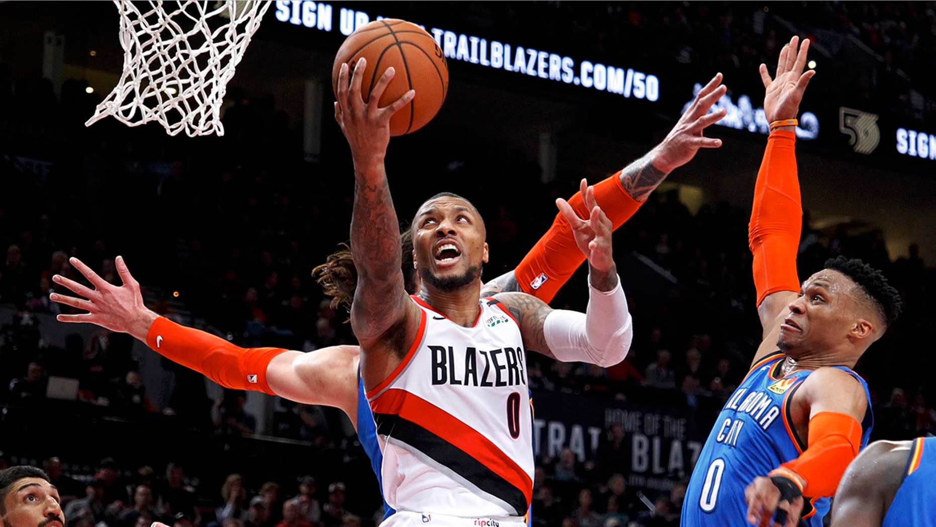 Portland Trail Blazers guard Damian Lillard, center, shoots as Oklahoma City Thunder guard Russell Westbrook, right, defends during the second half of Game 1 of a first-round NBA basketball playoff series in Portland, Ore., Sunday, April 14, 2019. (AP Photo/Steve Dipaola)