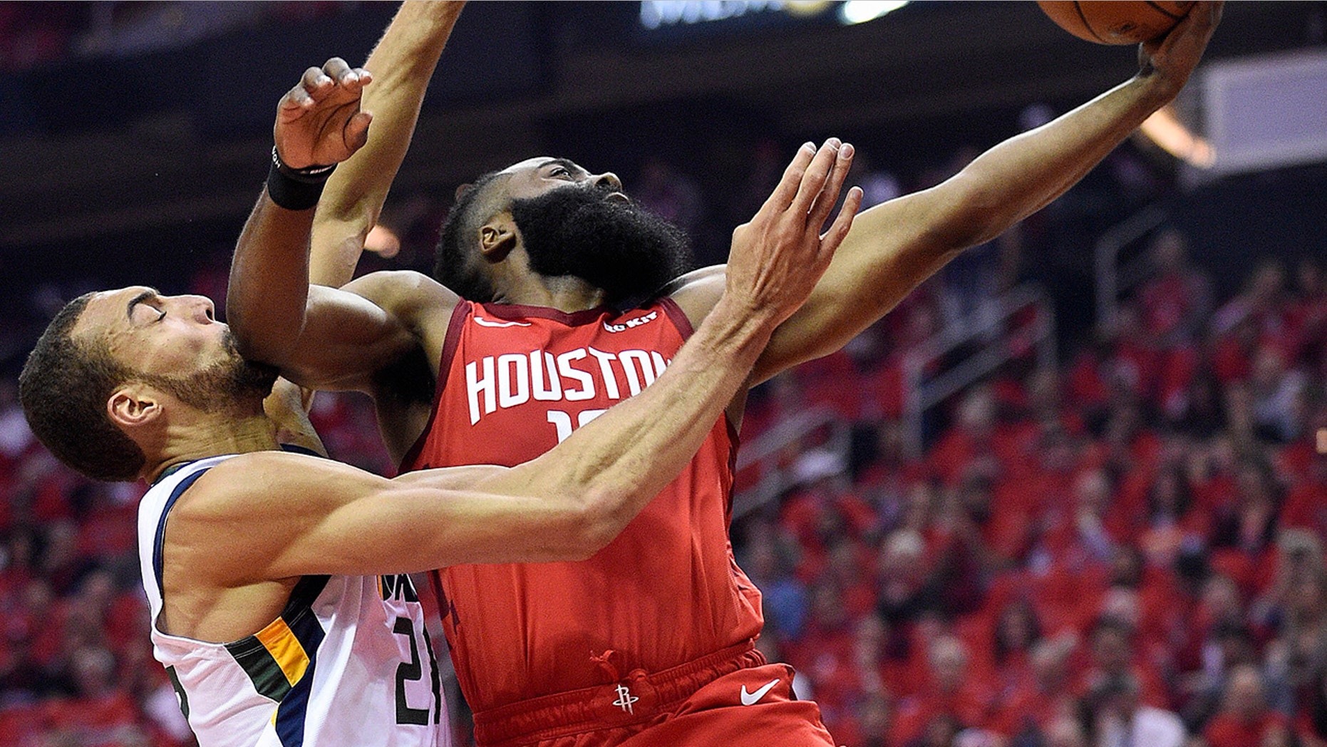 Houston Rockets guard James Harden, right, drives to the basket as Utah Jazz center Rudy Gobert defends during the first half of Game 1 of an NBA basketball first-round playoff series, Sunday, April 14, 2019, in Houston. (AP Photo/Eric Christian Smith)