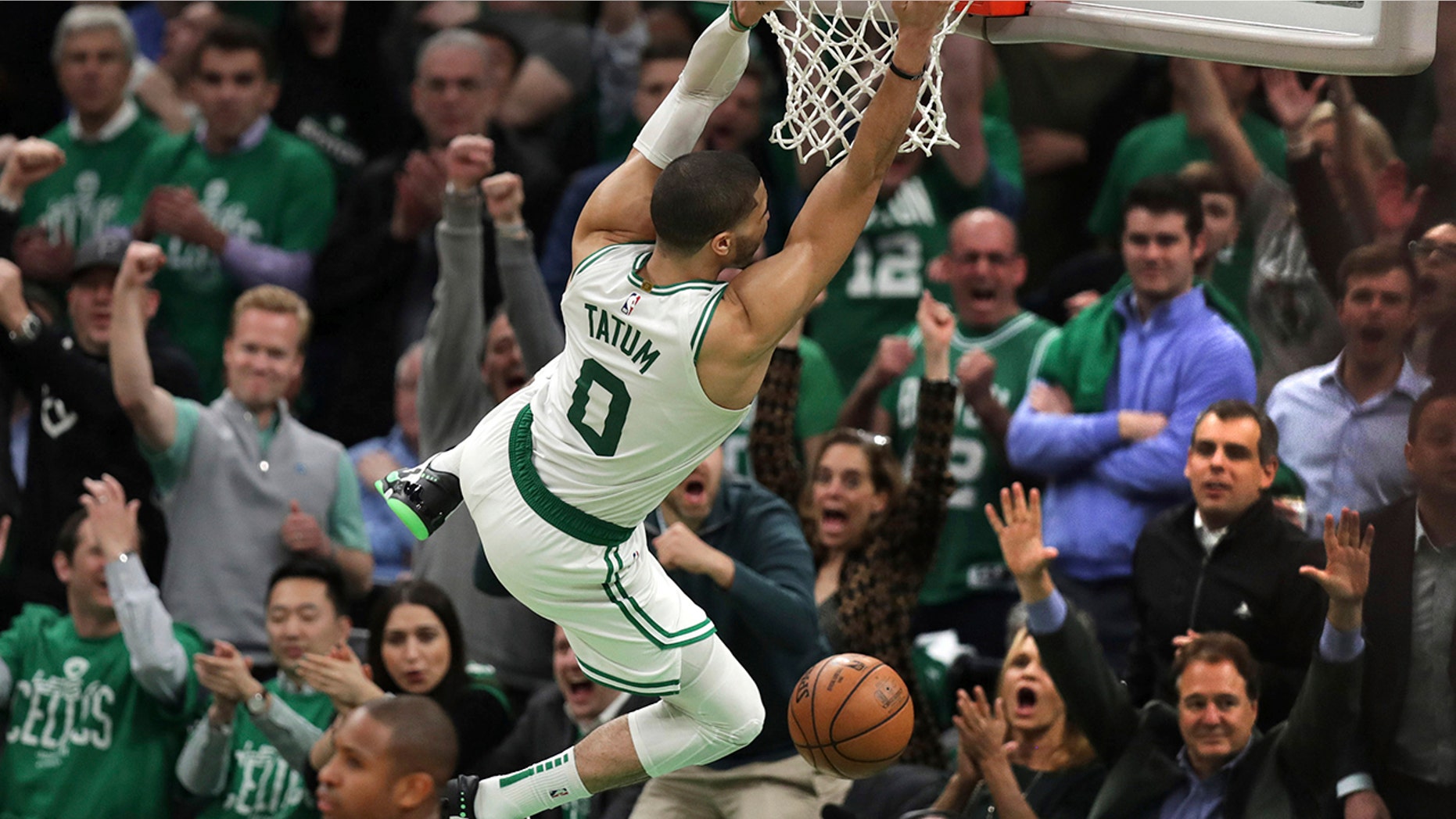 Boston Celtics forward Jayson Tatum (0) hangs on the rim after slamming a dunk against the Indiana Pacers in the final minute of the fourth quarter of Game 2 of an NBA basketball first-round playoff series, Wednesday, April 17, 2019, in Boston. The Celtics won 99-91. (AP Photo/Charles Krupa)