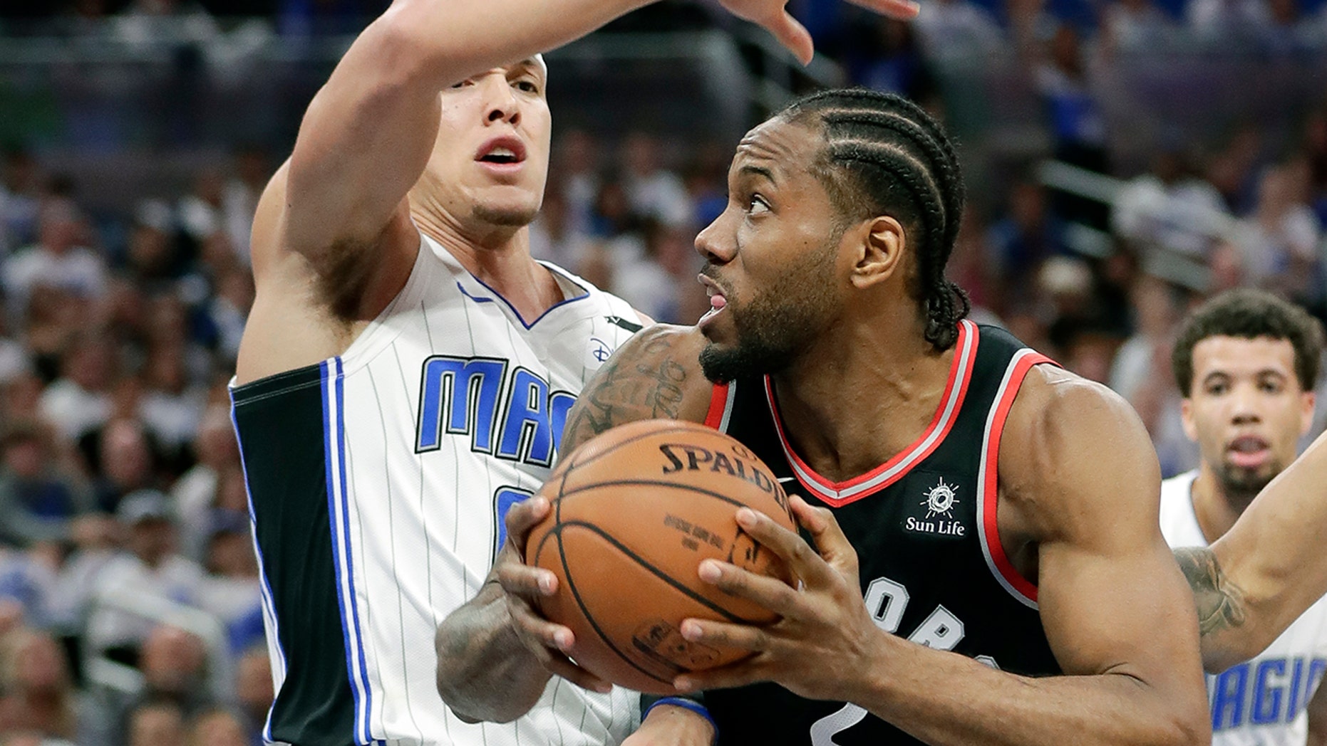 Toronto Raptors' Kawhi Leonard, right, looks looks for a shot as he is defended by Orlando Magic's Aaron Gordon during the first half in Game 3 of a first-round NBA basketball playoff series, Friday, April 19, 2019, in Orlando, Fla. (AP Photo/John Raoux)