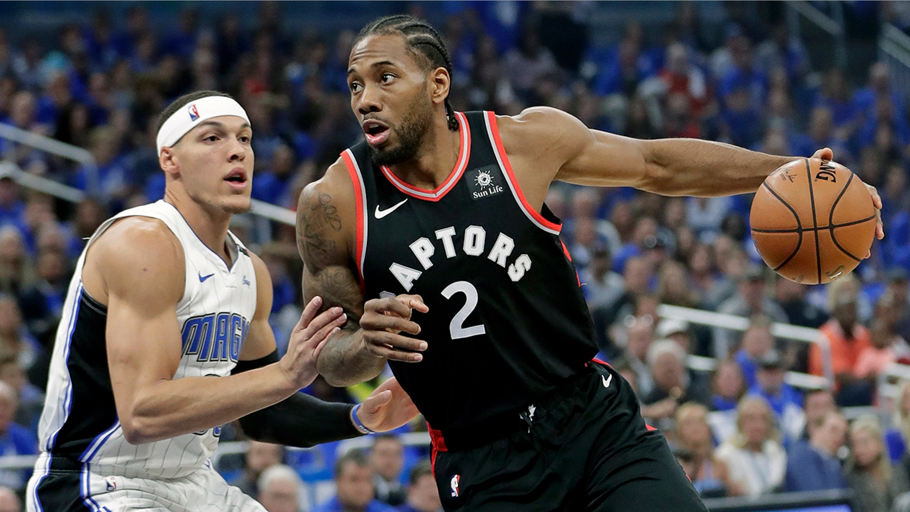 Toronto Raptors' Kawhi Leonard (2) drives to the basket against Orlando Magic's Aaron Gordon, left, during the first half in Game 4 of a first-round NBA basketball playoff series, Sunday, April 21, 2019, in Orlando, Fla. (AP Photo/John Raoux)