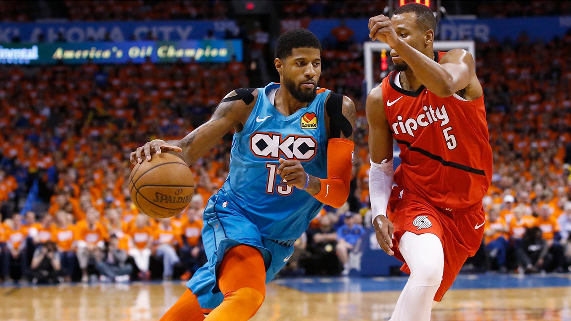 Oklahoma City Thunder forward Paul George (13) drives around Portland Trail Blazers guard Rodney Hood (5) in the first half of Game 3 of an NBA basketball first-round playoff series Friday, April 19, 2019, in Oklahoma City. (AP Photo/Sue Ogrocki)