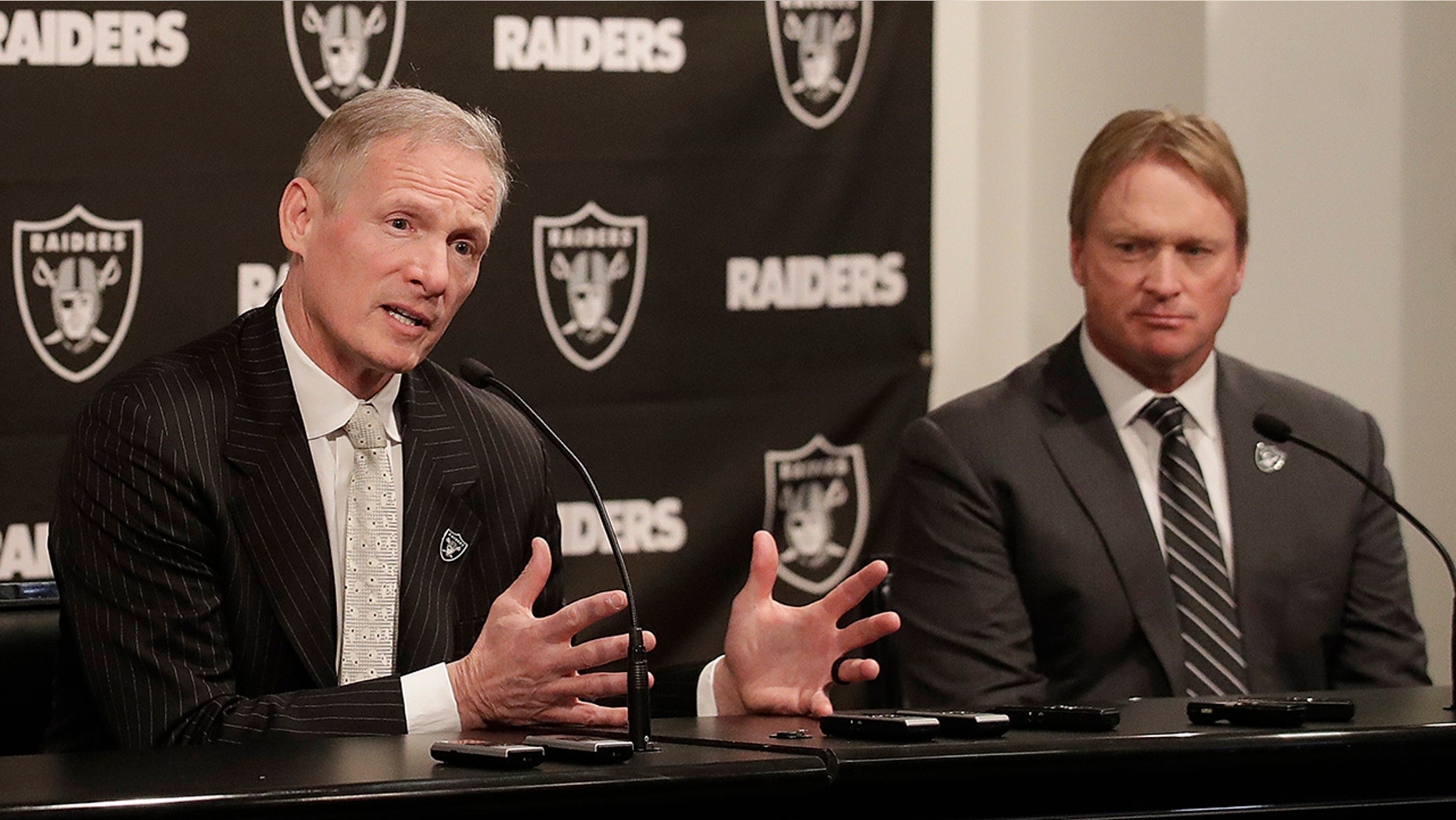 FILE - In this Monday, Dec. 31, 2018, file photo, Mike Mayock, left, speaks as Oakland Raiders head coach Jon Gruden listens at a news conference announcing Mayock as the general manager at the team's headquarters in Oakland, Calif. Mayock knows he will be highly scrutinized with three first-round picks thanks to Gruden's much-criticized trades. (AP Photo/Jeff Chiu, File)
