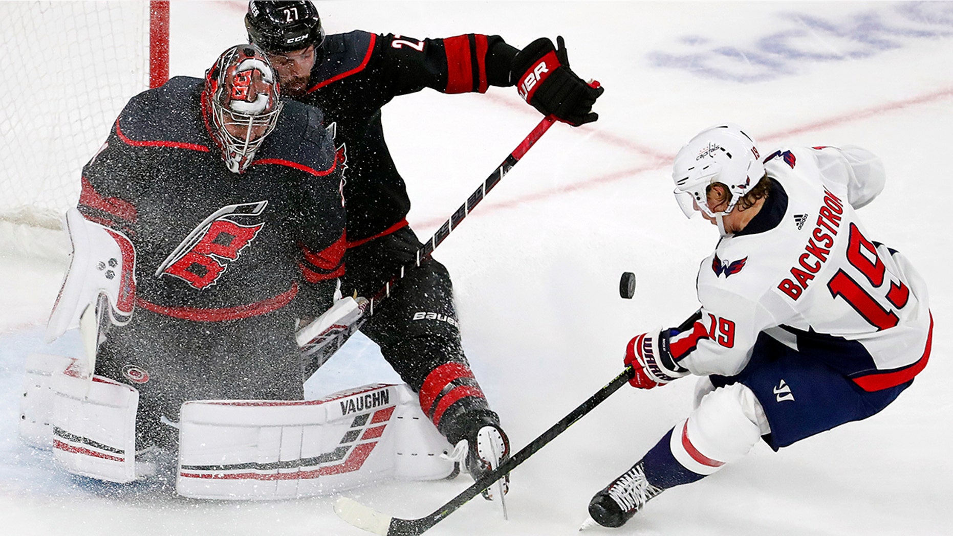 Carolina Hurricanes' Justin Faulk (27) assists goaltender Petr Mrazek (34) of the Czech Republic, in blocking the shot of Washington Capitals' Nicklas Backstrom (19) of Sweden, during the third period of Game 4 of an NHL hockey first-round playoff series in Raleigh, N.C, Thursday, April 18, 2019, (AP Photo/Karl B DeBlaker)
