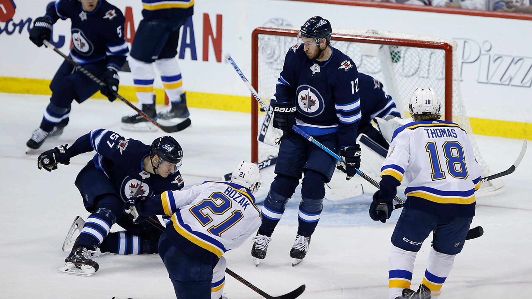 St. Louis Blues center Tyler Bozak (21) scores on Winnipeg Jets goaltender Connor Hellebuyck (37) as Jets defenseman Tyler Myers (57) and Jets right wing Kevin Hayes (12) defend during the third period of Game 1 of an NHL hockey first-round playoff series Wednesday, April 10, 2019, in Winnipeg, Manitoba. (John Woods/The Canadian Press via AP)