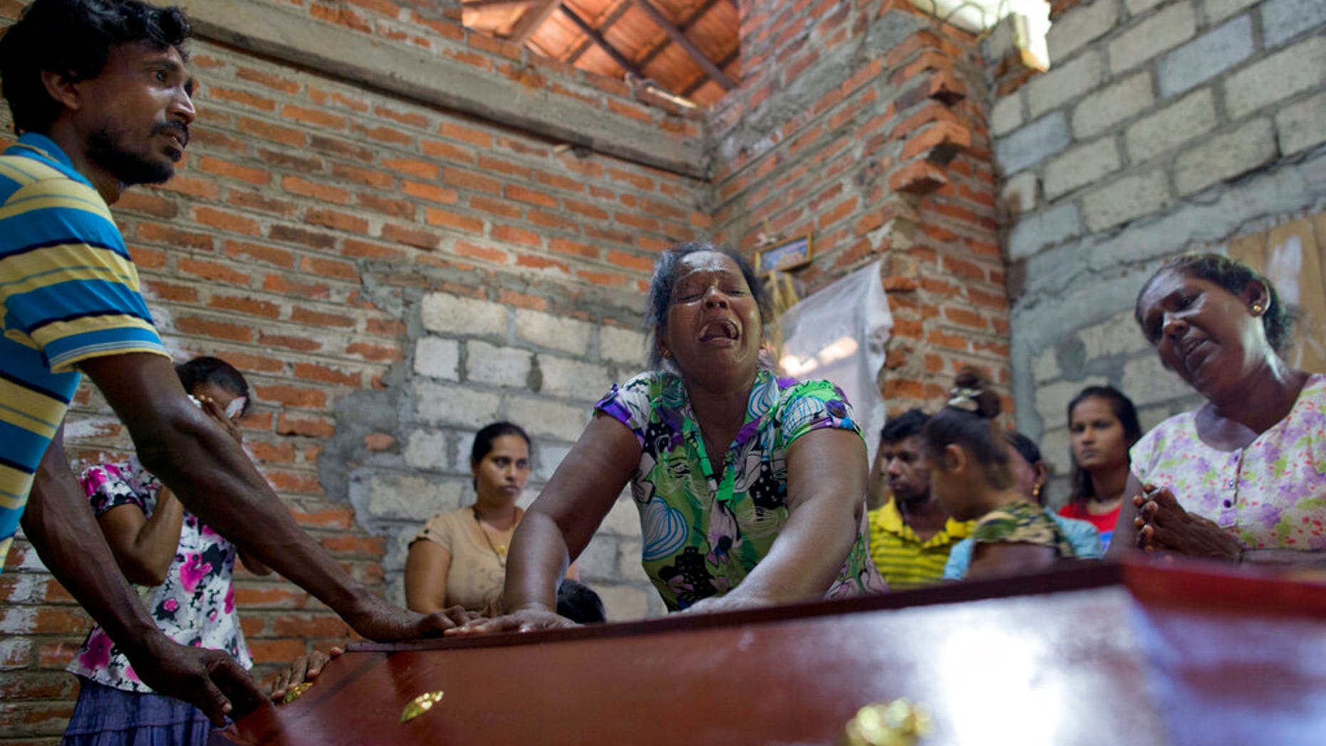 Lalitha, no centro, chora sobre o caixÃ£o com os restos mortais da sobrinha de 12 anos, Sneha Savindi, que foi vÃ­tima do atentado de domingo de PÃ¡scoa na igreja St. Sebastian, depois de voltar para casa em Negombo, Sri Lanka, segunda-feira, 22 de abril. 2019. (Foto AP / Gemunu Amarasinghe)