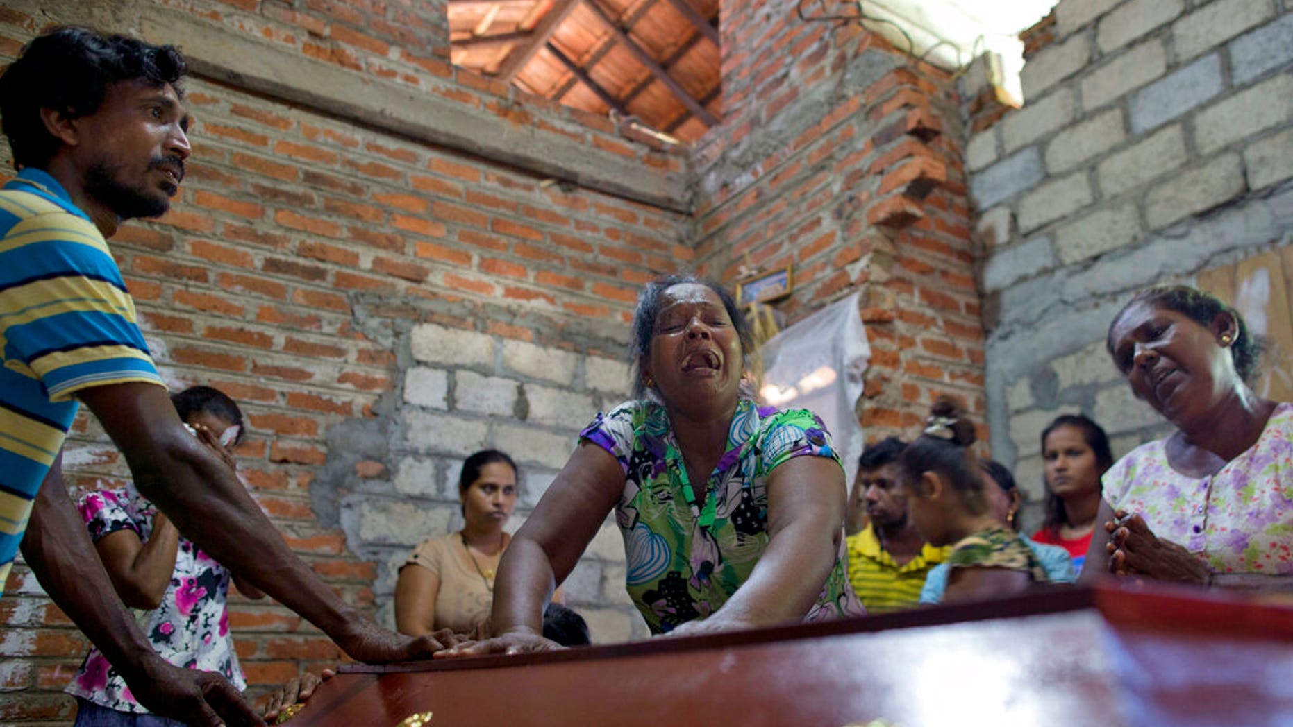 Lalitha, no centro, chora sobre o caixão com os restos mortais da sobrinha de 12 anos, Sneha Savindi, que foi vÃtima do atentado de domingo de Páscoa na igreja St. Sebastian, depois de voltar para casa em Negombo, Sri Lanka, segunda-feira, 22 de abril. 2019. (Foto AP / Gemunu Amarasinghe)