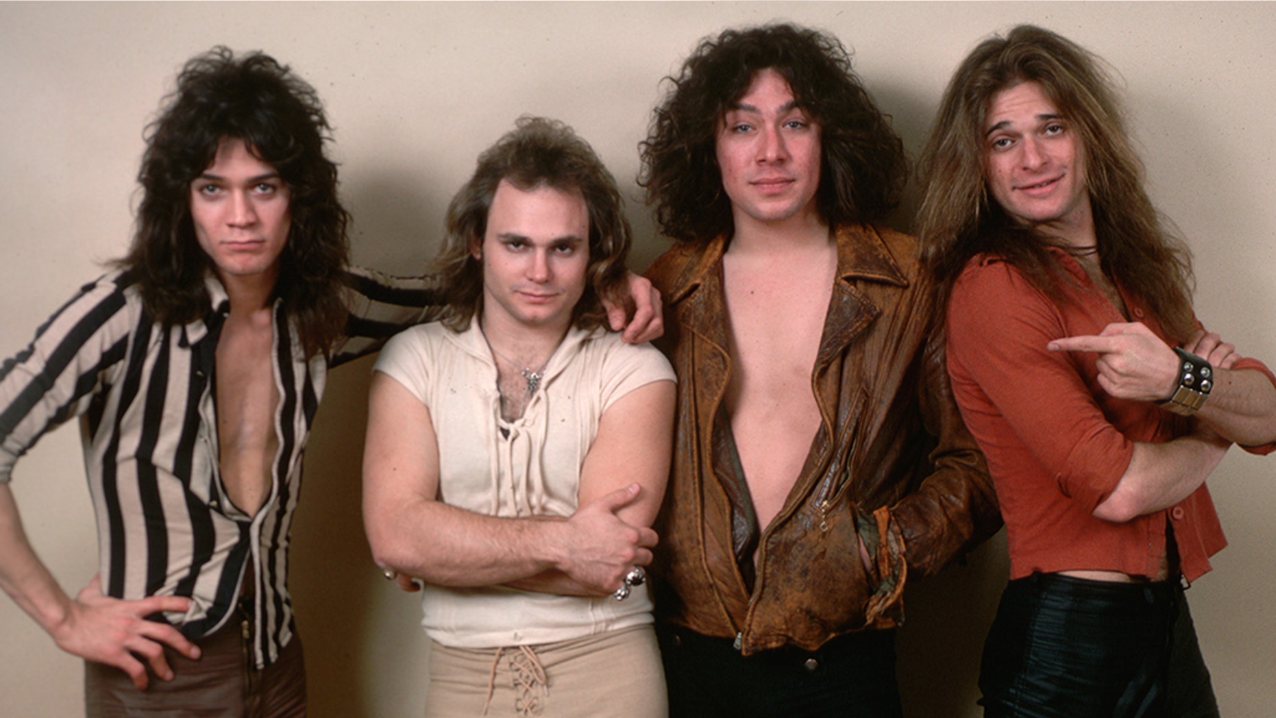 (Original Caption) : 1978- Picture shows the four members of the band Van Halen (left to right) Eddie Van Halen, Michael Anthony, Alex Van Halen and David Lee Roth. They are standing next to one-another in front of a white wall. (Photo by Lynn Goldsmith/Corbis/VCG via Getty Images)