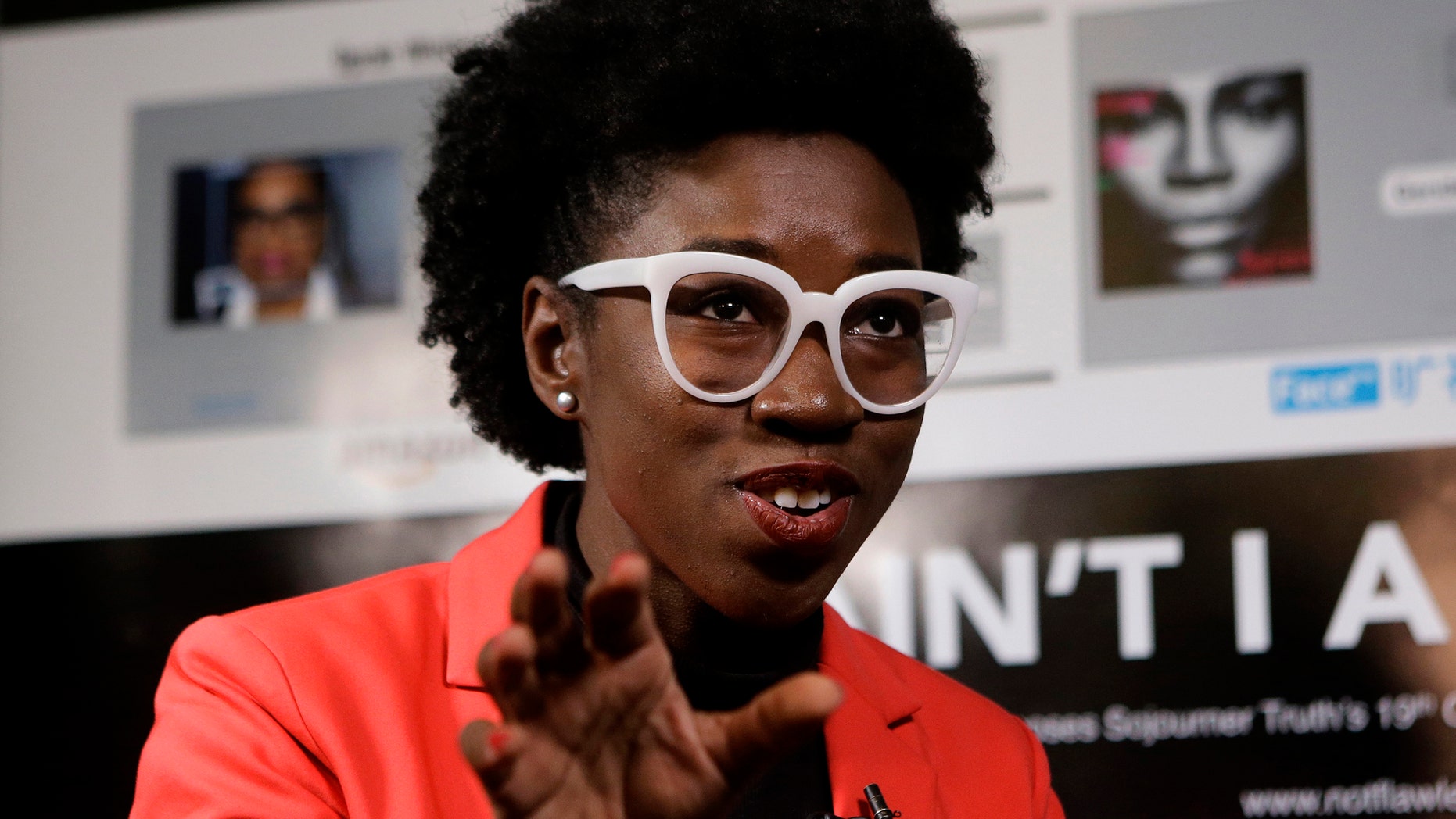 In this Wednesday, Feb. 13, 2019, photo, Massachusetts Institute of Technology facial recognition researcher Joy Buolamwini takes questions from reporters at the school, in Cambridge, Mass. Buolamwini's research has uncovered racial and gender bias in facial analysis tools sold by companies such as Amazon that have a hard time recognizing certain faces, especially darker-skinned women. (AP Photo/Steven Senne)