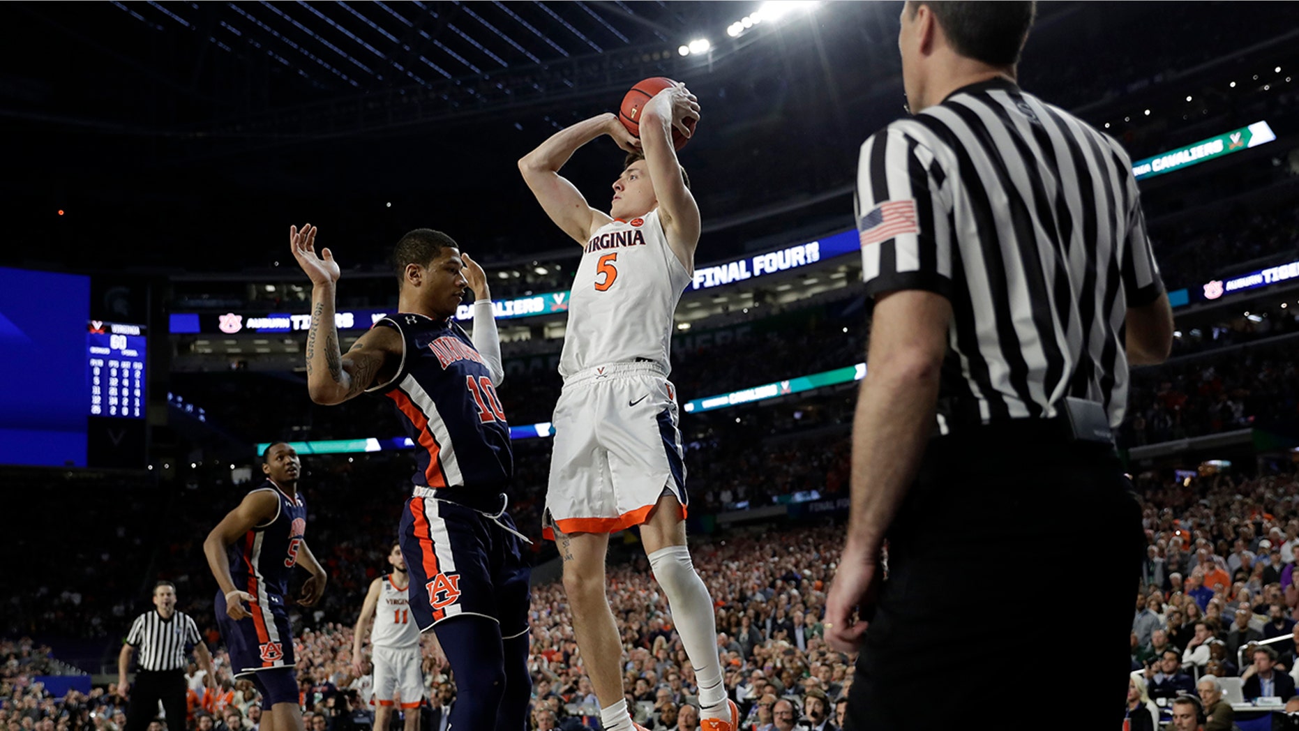 Virginia's Kyle Guy (5) takes a shot as Auburn's Samir Doughty (10) was called foul during the second half in the semifinals of the Final Four NCAA college basketball tournament, Saturday, April 6, 2019, in Minneapolis. (Associated Press)