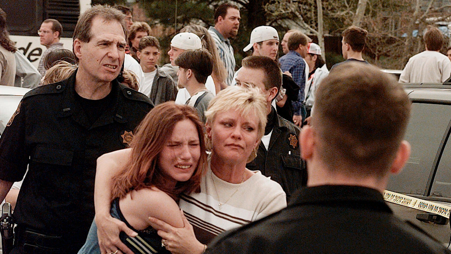 FEATURE - On April 20, 1999, a woman kissed her daughter after their meeting after the shooting at Columbine High School in Littleton, Colorado. side. Images of the scene showed terrified students fleeing from school, SWAT officers waiting to enter and a wounded boy trying to escape through a window. (AP Photo / Ed Andrieski, File)