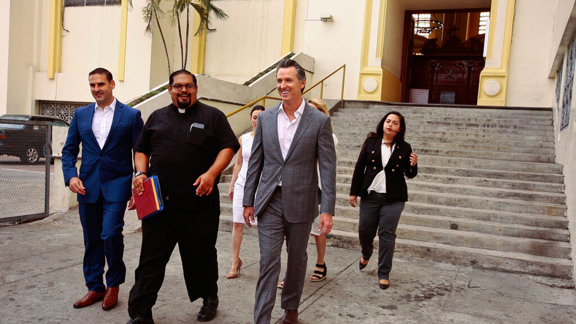 California Gov. Gavin Newsom, second from right, walks out with San Salvador Mayor Ernesto Muyshondtof, far left, after they visited the tomb of Archbishop Oscar Romero at Metropolitan Cathedral in San Salvador, El Salvador.
