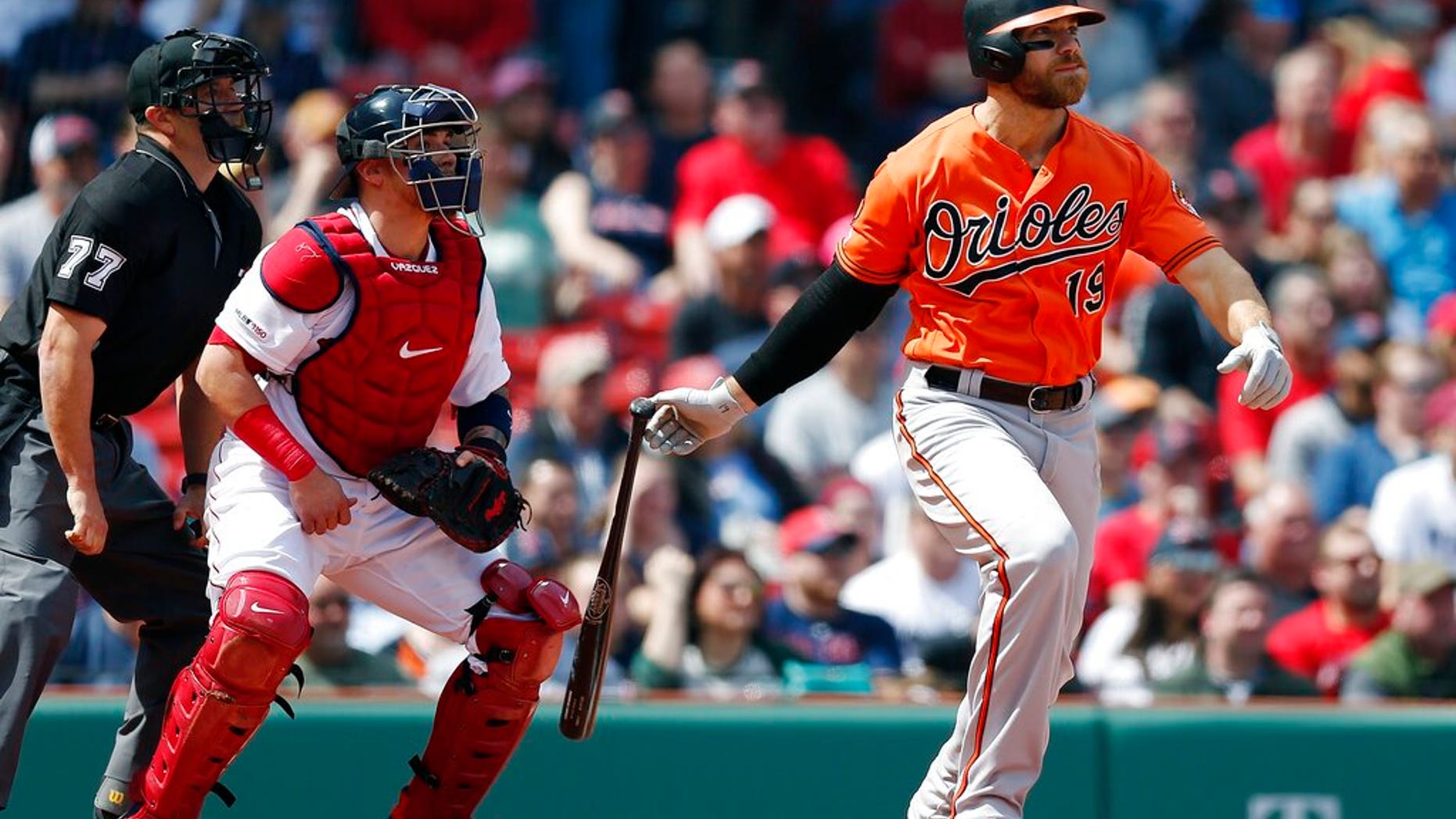 Baltimore Orioles' Chris Davis watches his two-run single in front of Boston Red Sox's Christian Vazquez during the first inning of a baseball game in Boston, Saturday, April 13, 2019.