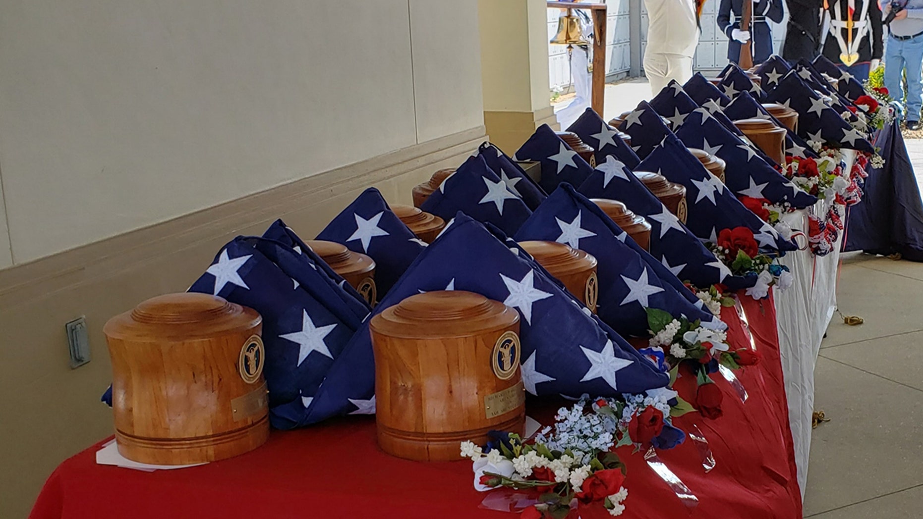 A table holds wood urns containing the cremated remains of 25 American veterans who were buried Saturday at South Florida National Cemetery in a special ceremony.