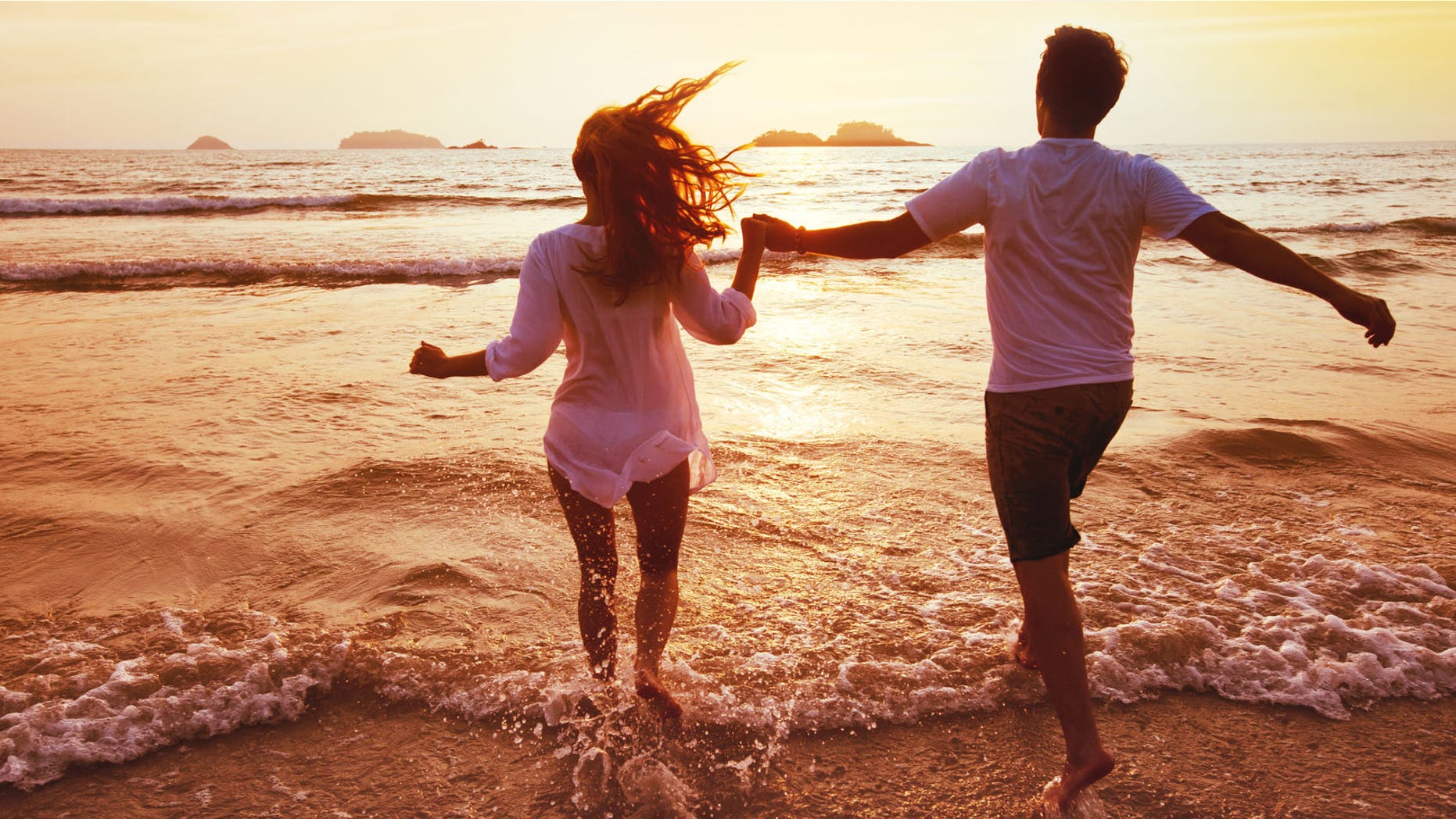 happy couple on honeymoon vacation travel, romantic dream beach holidays, happiness background, silhouettes of man and woman running to the sea at sunset together