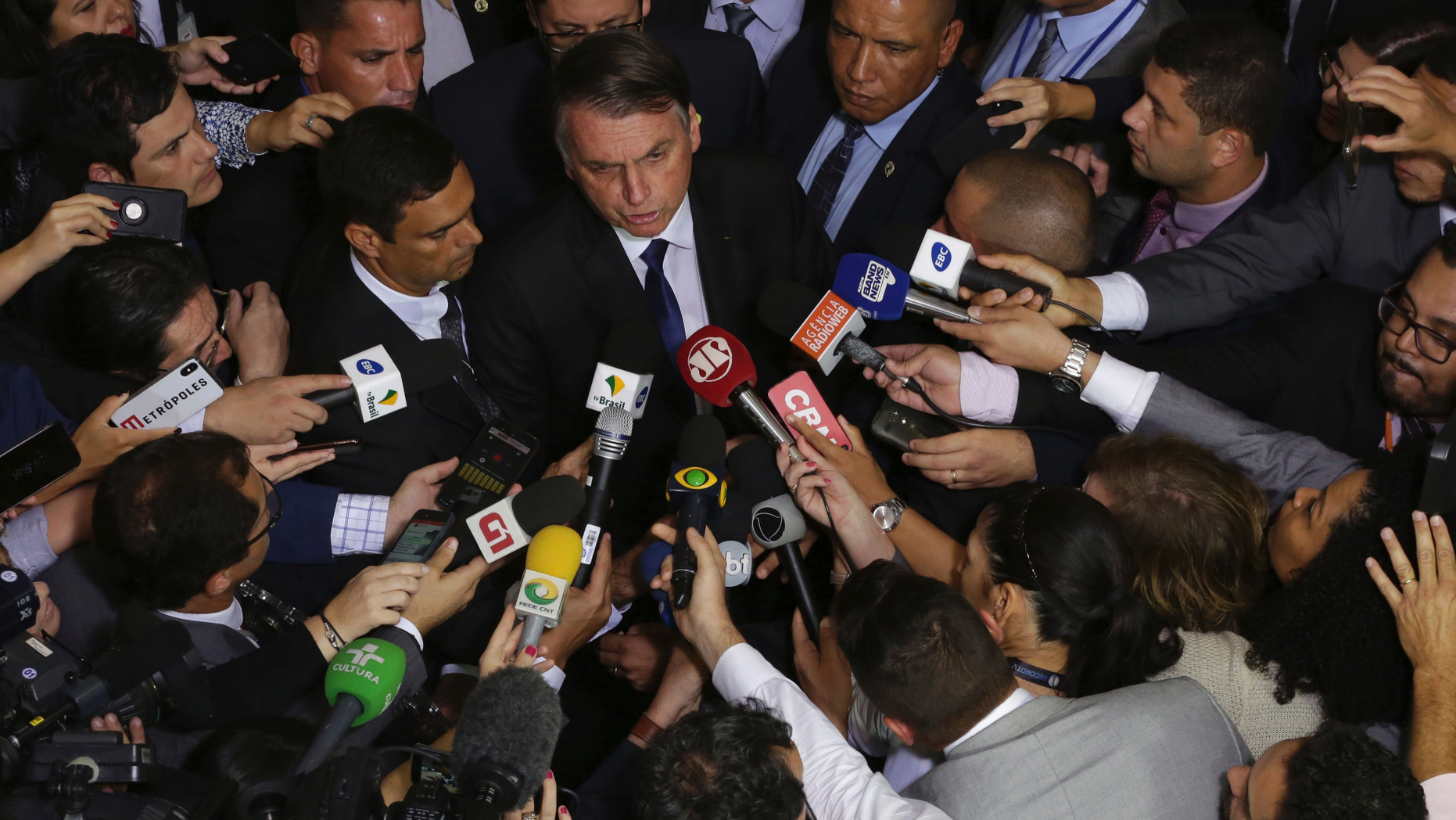 Brazil's President Jair Bolsonaro speaks to the press after signing a second decree that eases gun restrictions, at the Planalto presidential palace in Brasilia, Brazil, Tuesday, May 7, 2019. The decree opens Brazil’s market to guns and ammunition made outside of Brazil according to a summary of the decree. Gun owners can now buy between 1,000 -5,000 rounds of ammunition per year depending on their license, up from 50 rounds. Lower-ranking military members can now carry guns after 10 years of service. (AP Photo/Eraldo Peres)