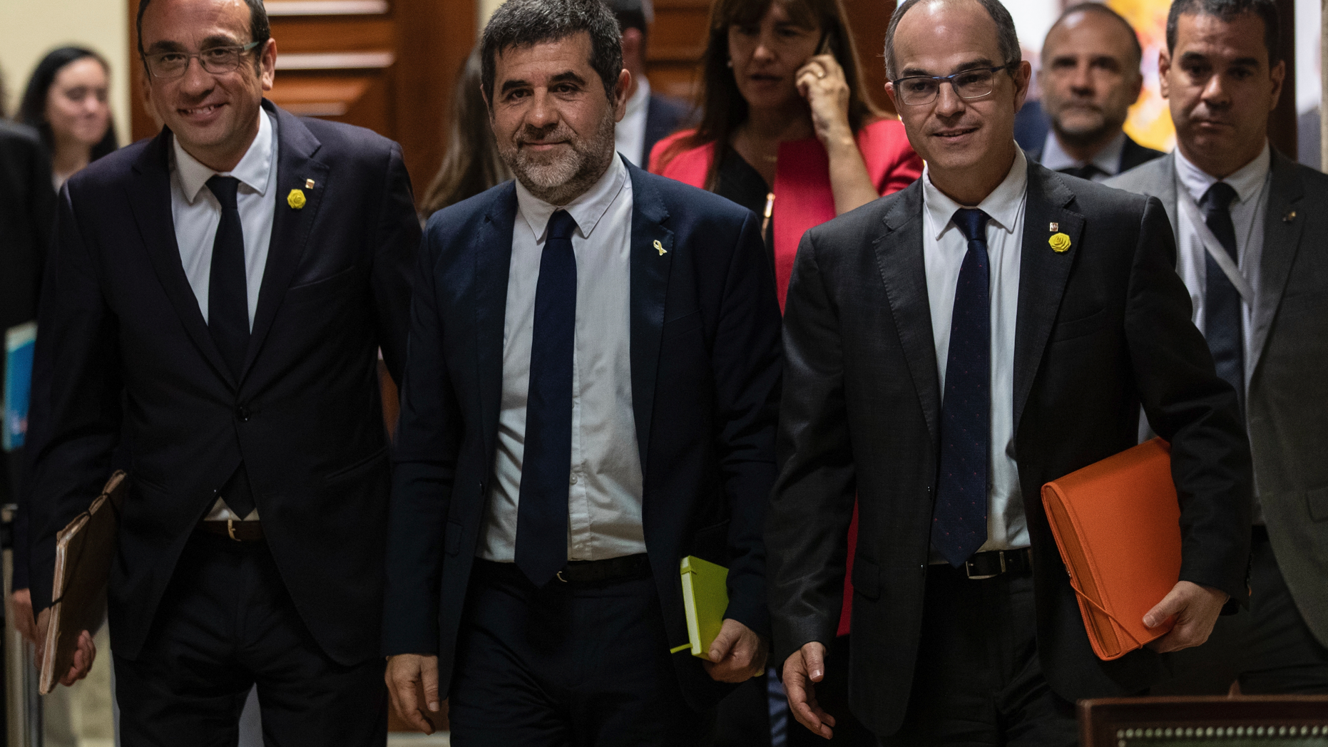 Catalan politicians Josep Rull, left, Jordi Sanchez and Jordi Turull, right, leave after collecting their credentials at the Spanish parliament in Madrid, Spain, Monday, May 20, 2019. The five separatist leaders on trial for Catalonia's 2017 secession attempt who were elected to the Spanish Parliament in April 28 elections have been escorted by police to pick up their official credentials. The five, along with other defendants, are being held in pre-trial jail. They face several years in prison if found guilty of rebellion. (AP Photo/Bernat Armangue)