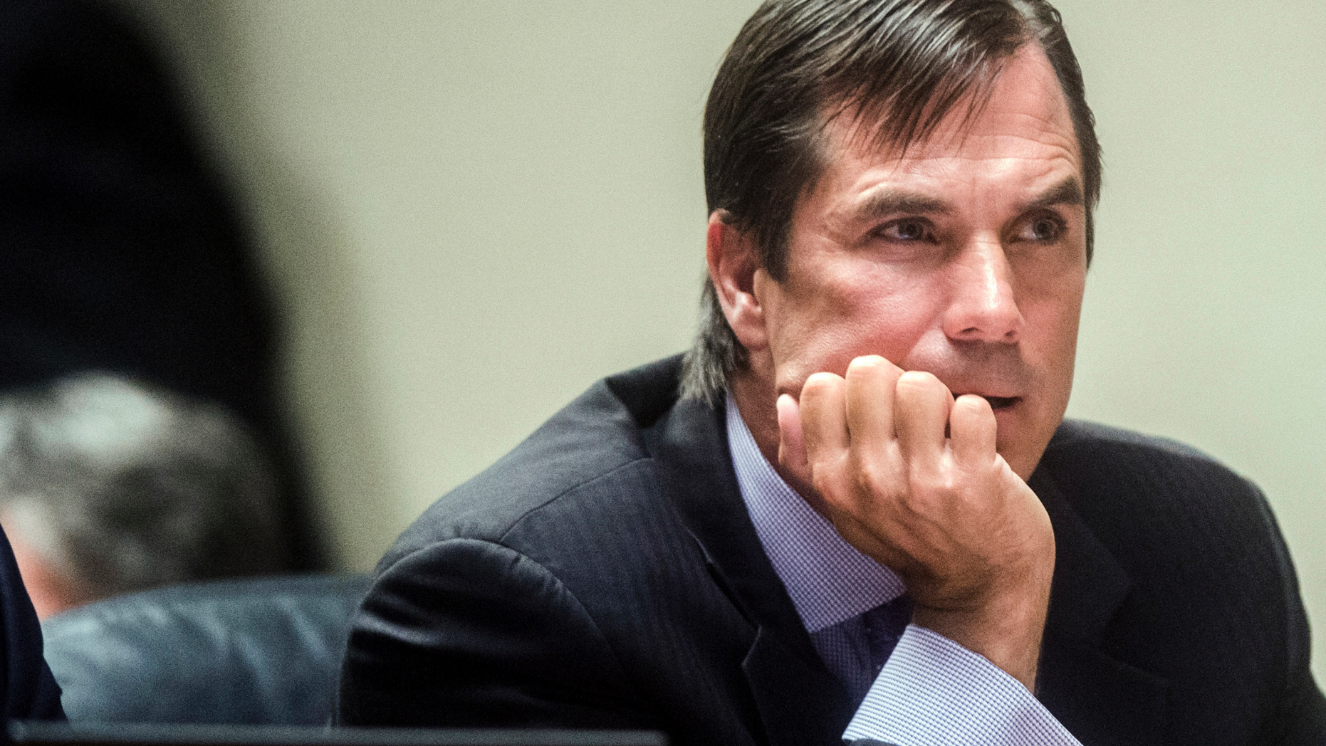 FILE - In this Aug. 20, 2018, file photo, Nick Lyon, director of the Michigan Department of Health and Human Services, listens closely as Genesee District Judge David J. Goggins gives his decision during Lyon's preliminary examination at Genesee District Court in Flint, Mich. Lawyers for Lyon are vigorously opposing an effort to put his Flint water criminal case on hold for six months, saying it's a sign of the prosecution team's "dysfunction." The attorney general's office says it needs a timeout so it can dig through 23 boxes of records found in the basement of a state building. (Jake May/The Flint Journal via AP, File)