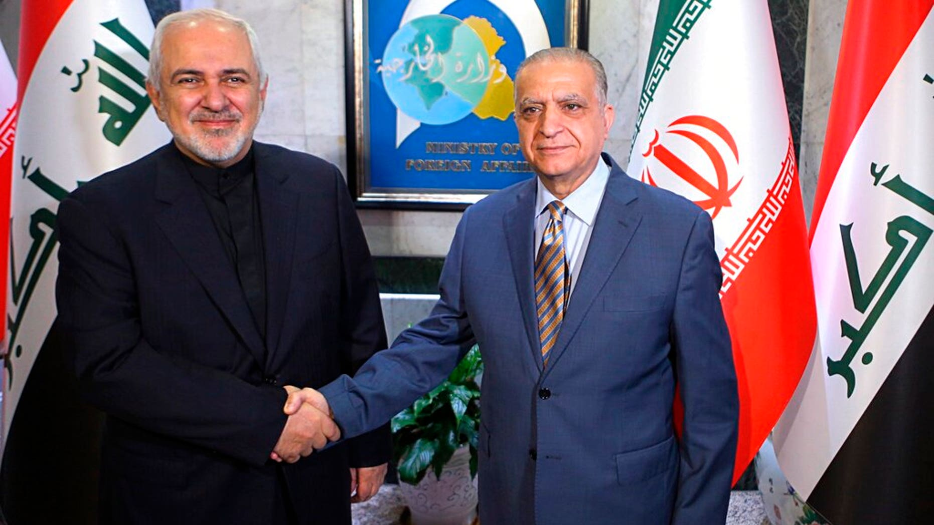 Iraqi Foreign Minister Mohamed Alhakim, right, shakes hands with his visiting Iranian counterpart Mohammad Javad Zarif at the Ministry of Foreign Affairs Building in Baghdad, Iraq.