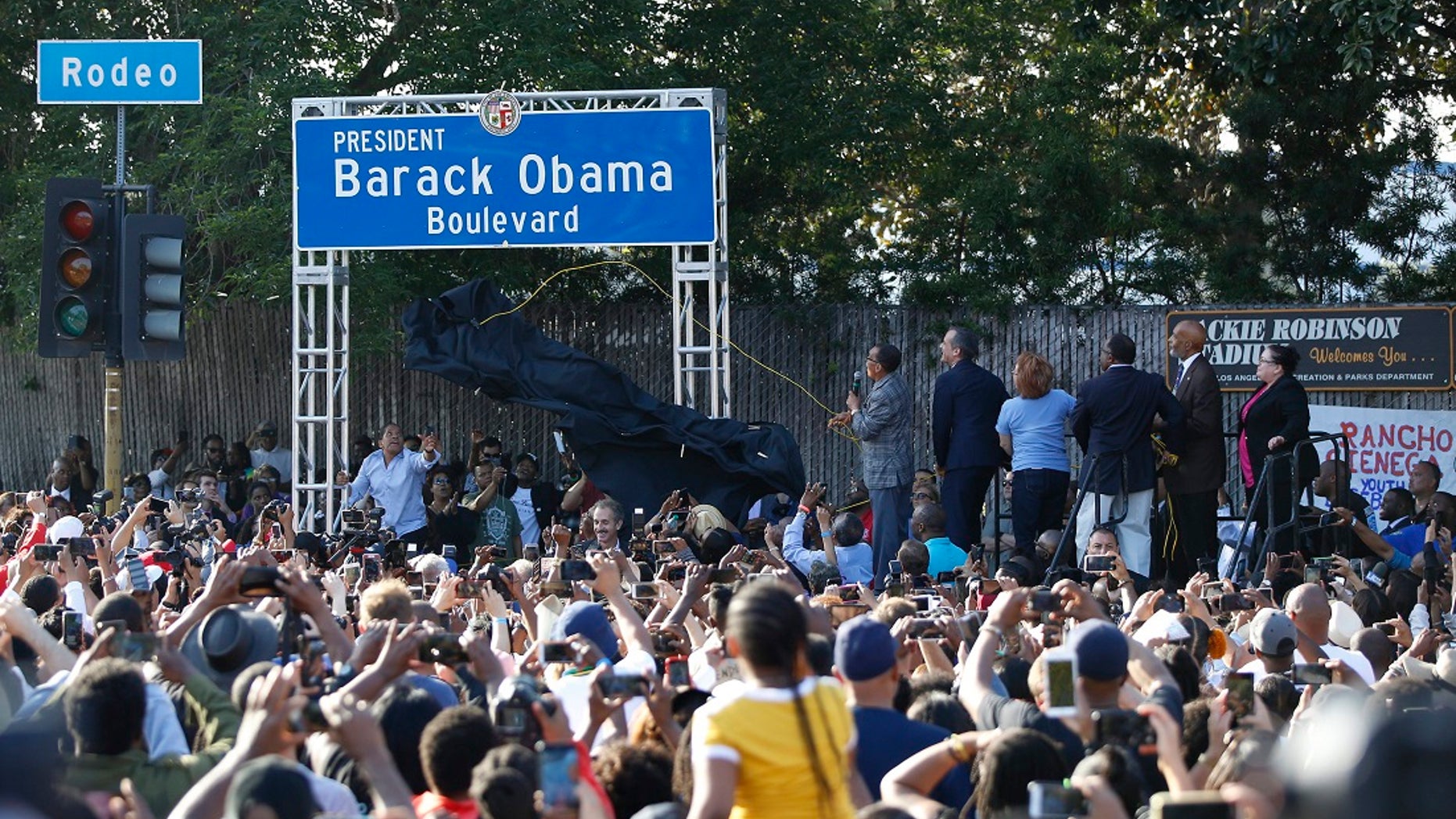 City officials, at podium on right, unveil the "President Barack Obama Boulevard" sign in Los Angeles on Saturday. (Associated Press)