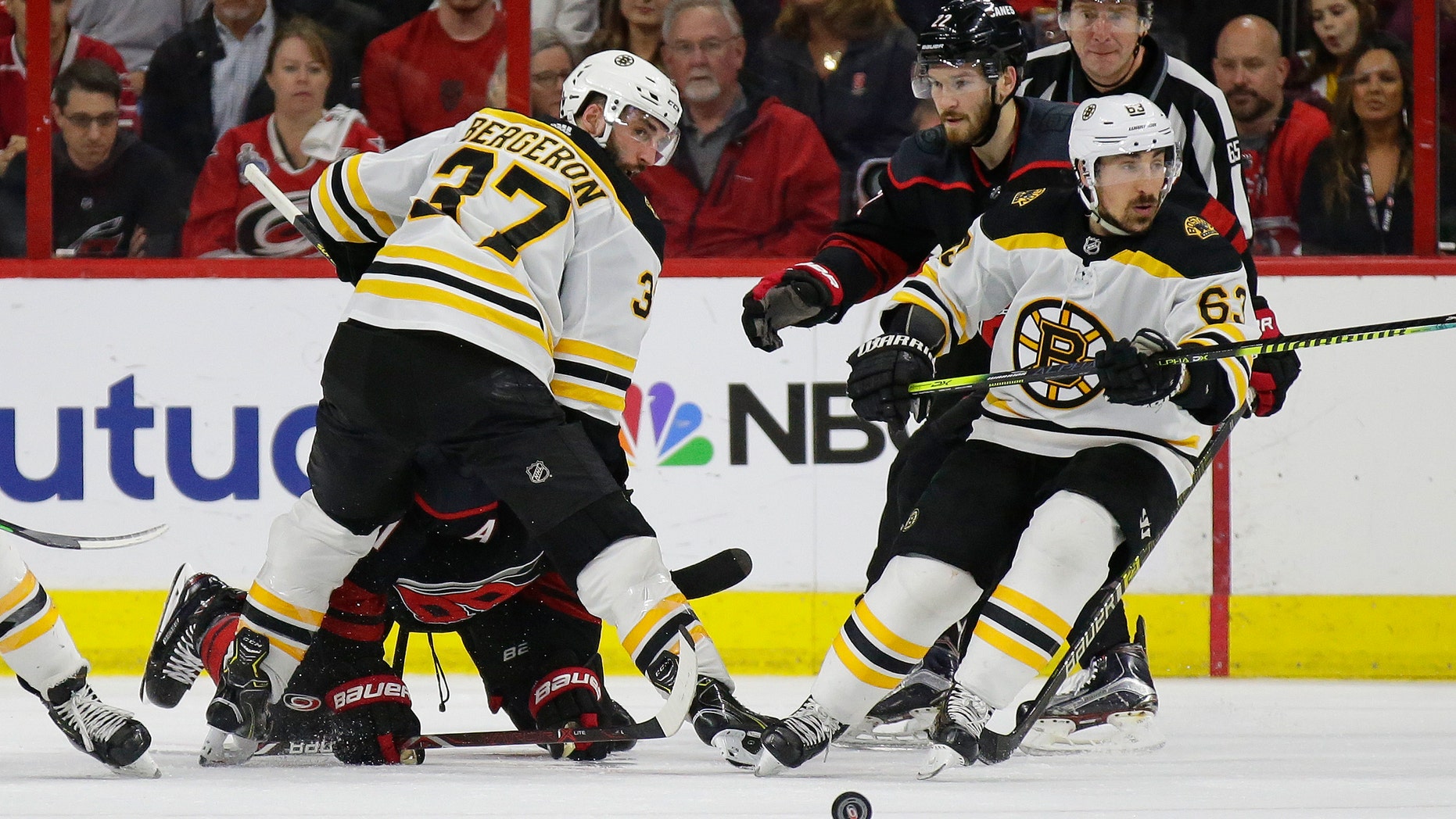 Boston Bruins' Patrice Bergeron (37) and Brad Marchand (63) skate for the puck with Carolina Hurricanes' Brett Pesce (22) and Jordan Staal during the second period in Game 3 of the NHL hockey Stanley Cup Eastern Conference final series in Raleigh, N.C., Tuesday, May 14, 2019. (Associated Press)
