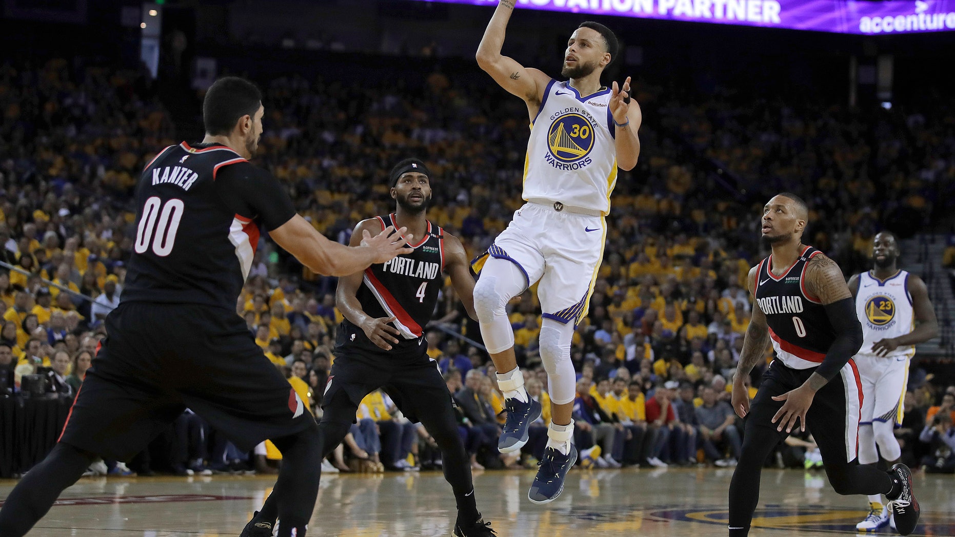 Golden State Warriors' Stephen Curry (30) shoots between Portland Trail Blazers' Maurice Harkless (4), Enes Kanter (00) and Damian Lillard, right, during the first half of Game 1 of the NBA basketball playoffs Western Conference finals Tuesday, May 14, 2019, in Oakland, Calif.