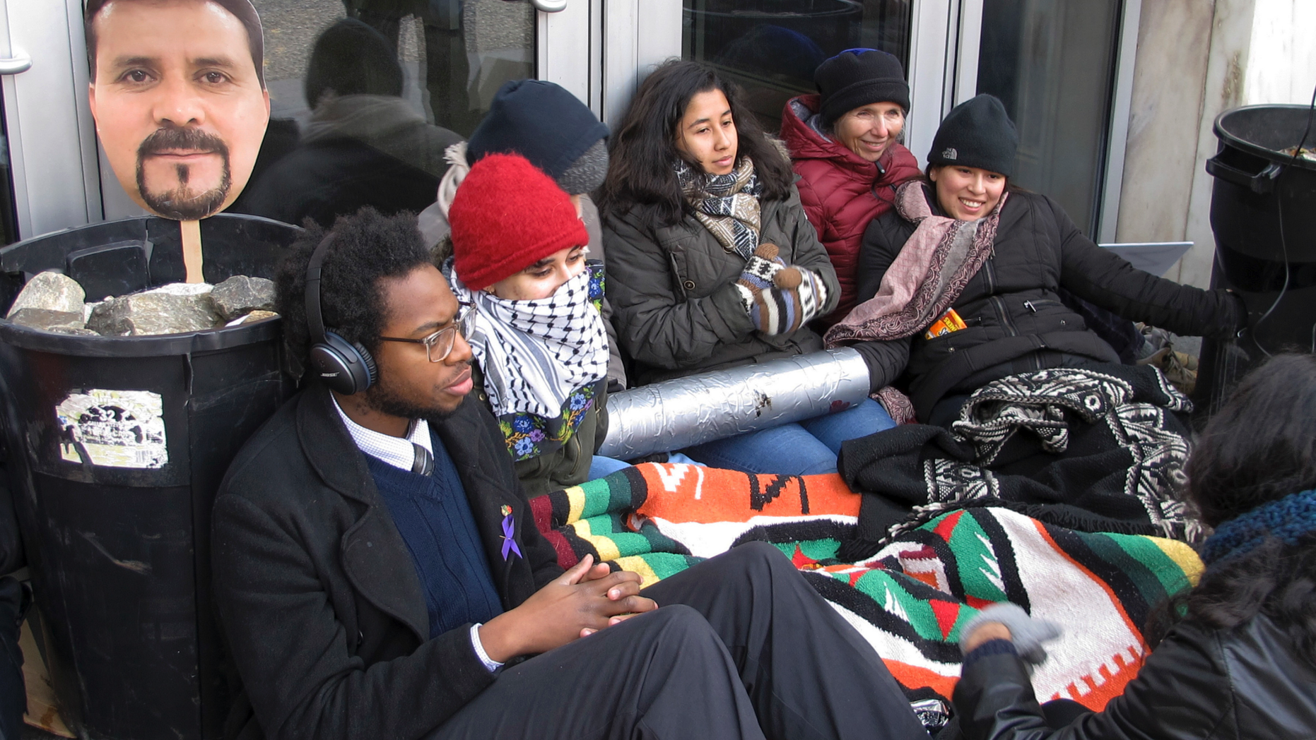 FILE - In this Nov. 30, 2018 file photo, supporters of Nelson Pinos, an immigrant from Ecuador who has been living in a church for a year to avoid deportation, block the front doors outside the federal building, in Hartford, Conn. An attorney for Pinos, who was arrested in Minneapolis and ordered deported from the U.S. 25 years ago, goes to court Tuesday, May 13, 2019, to ask that his case be reopened. (AP Photo/Dave Collins, File)