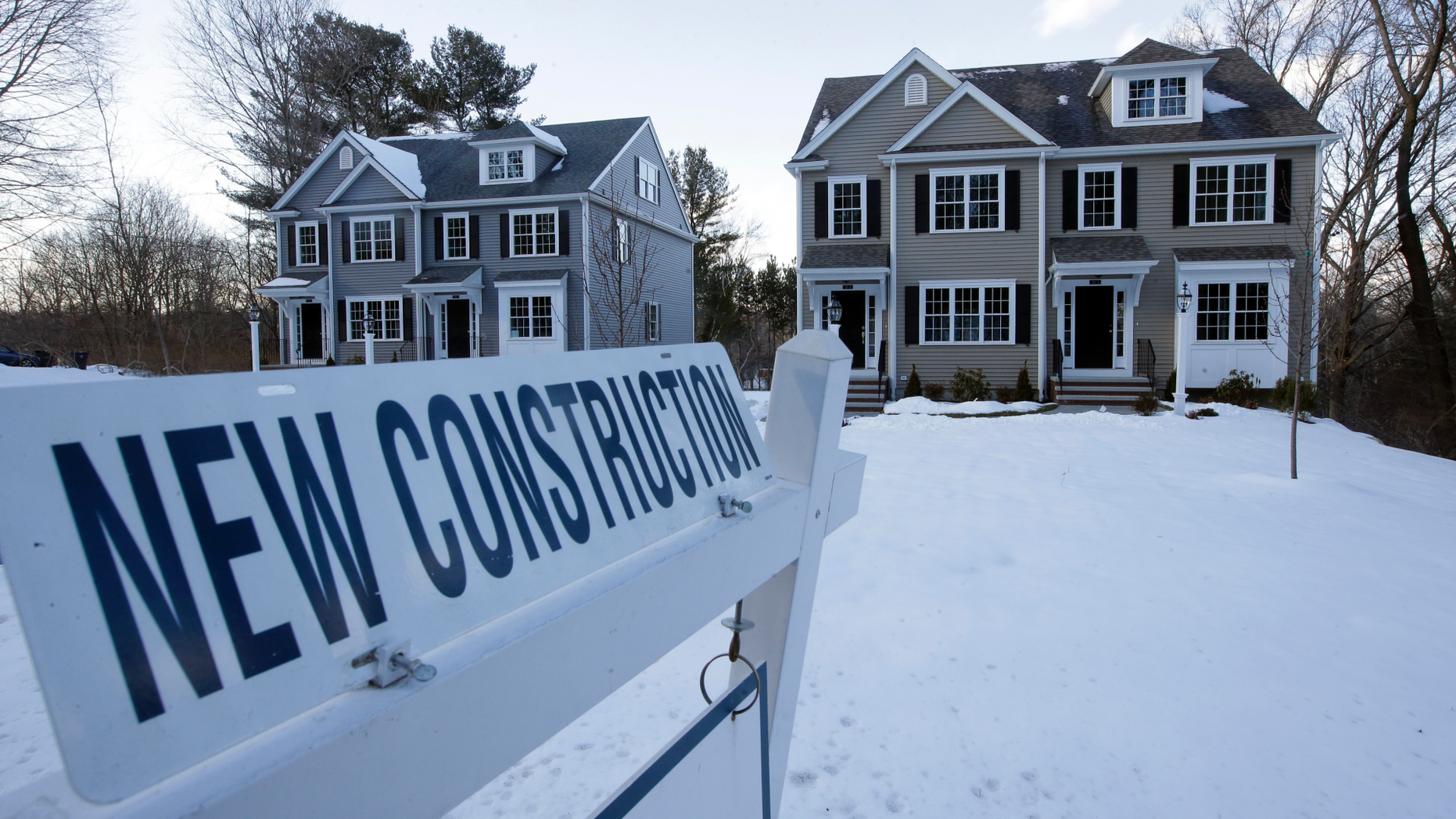 FILE- In this Feb. 21, 2019, file photo a newly constructed homes sit near a sign in Natick, Mass. On Thursday, May 23, the Commerce Department reports on sales of new homes in April. (AP Photo/Steven Senne, File)