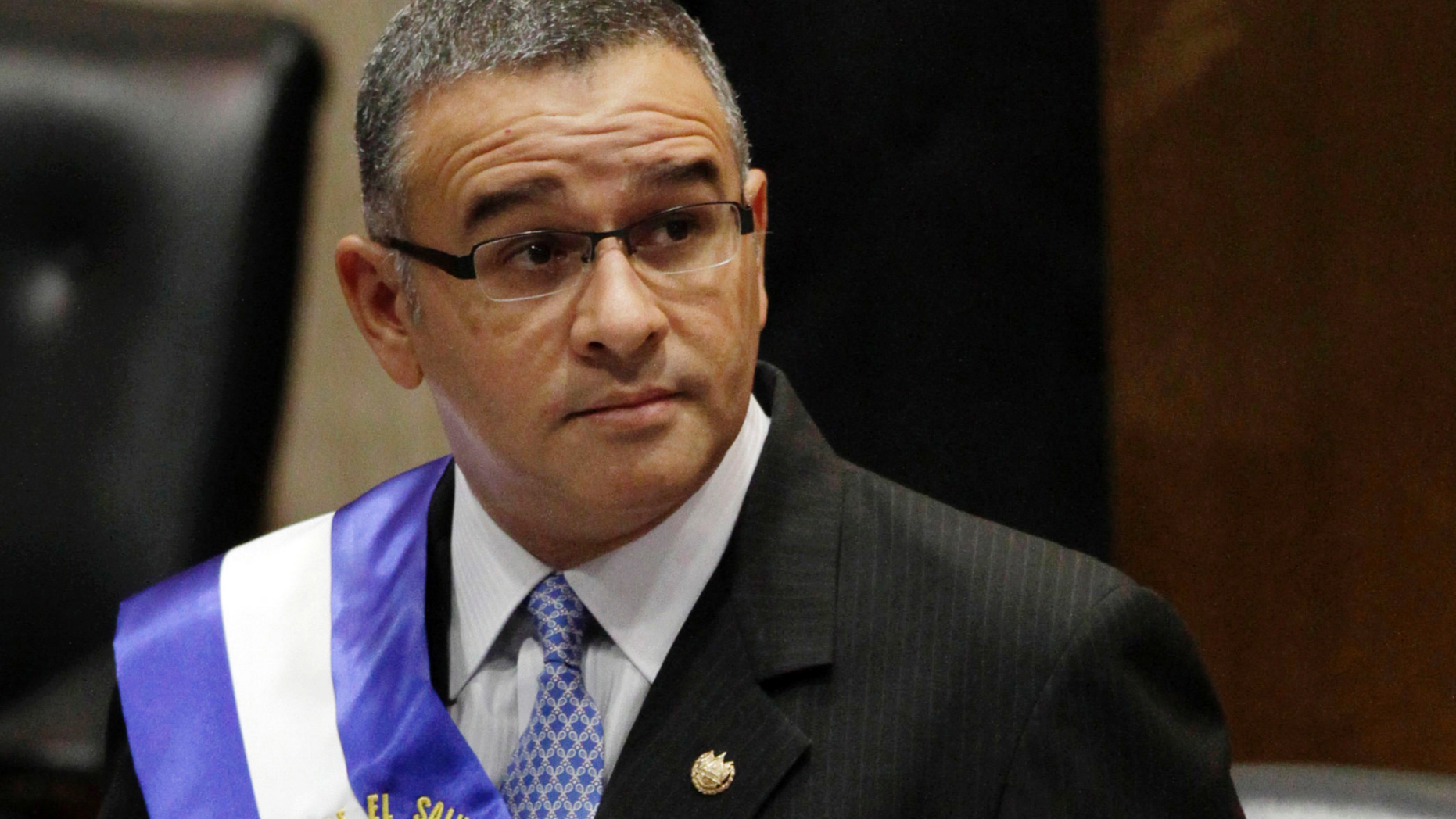 FILE - In this June 1, 2012 file photo, El Salvador's President Mauricio Funes stands in the National Assembly before speaking to commemorate the anniversary of his third year in office in San Salvador, El Salvador. Funes, who is a fugitive of El Salvador’s courts and lives under political asylum in Nicaragua, said Monday, May 13, 2019, that he is working as an adviser to the government of Nicaraguan President Daniel Ortega. (AP Photo/Luis Romero, File)