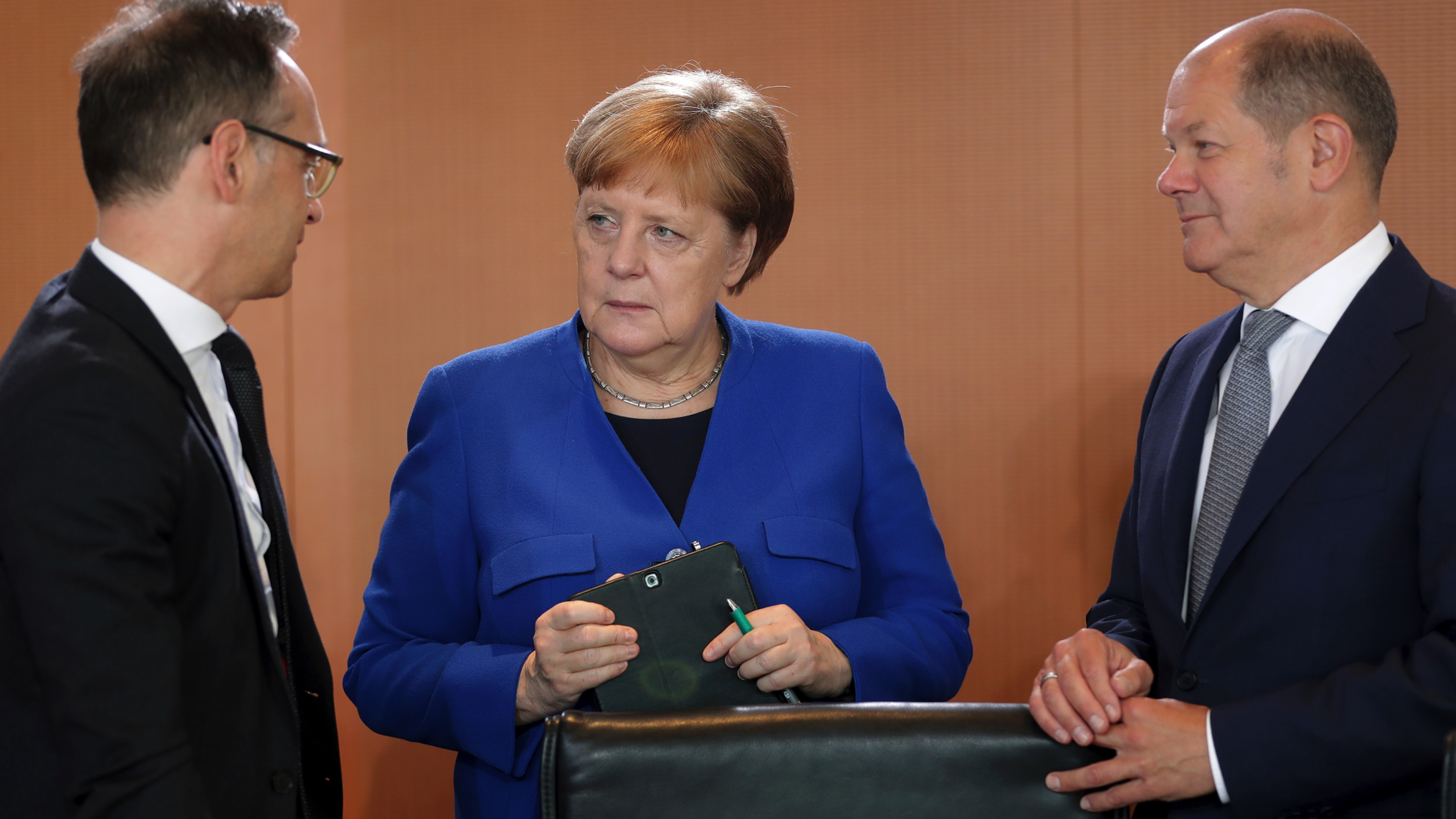 German Chancellor Angela Merkel, center, German Foreign Minister Heiko Maas, left, and German Finance Minister Olaf Scholz talk as they arrive for the weekly cabinet meeting at the chancellery in Berlin, Germany, Wednesday, May 15, 2019. (AP Photo/Michael Sohn)